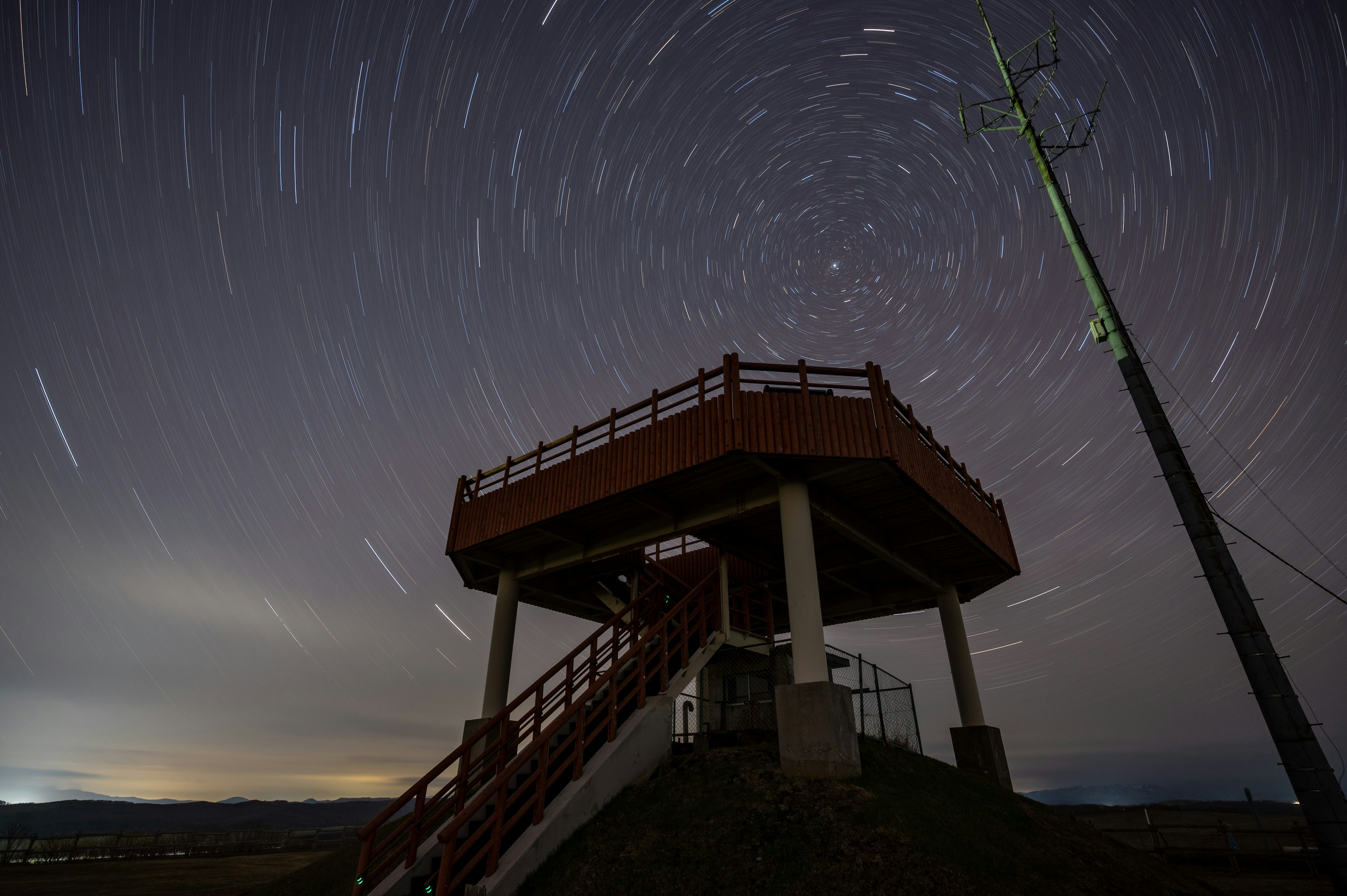 星空の下にある展望台と星の軌跡