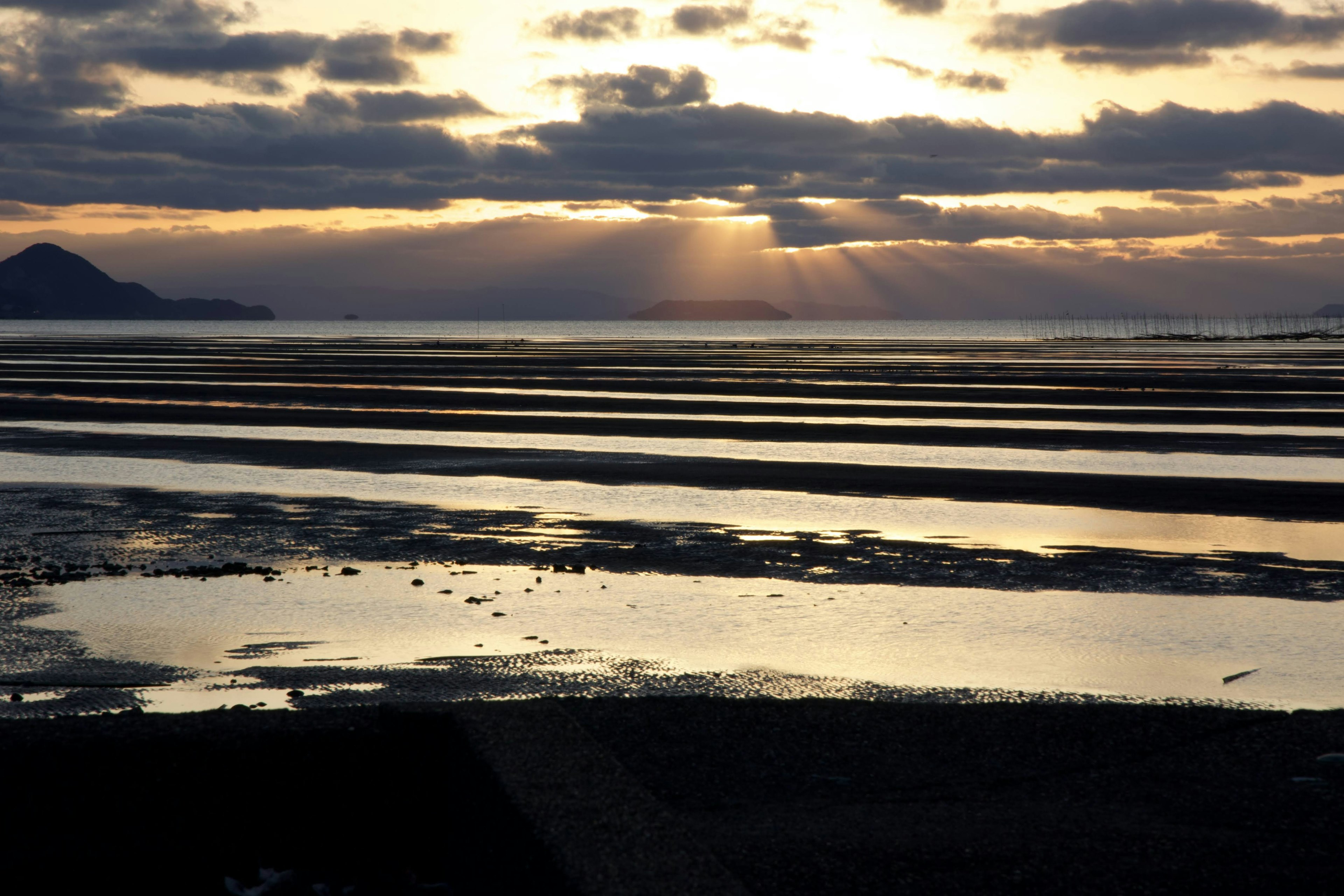 Coastal landscape with rays of light reflecting on tidal flats