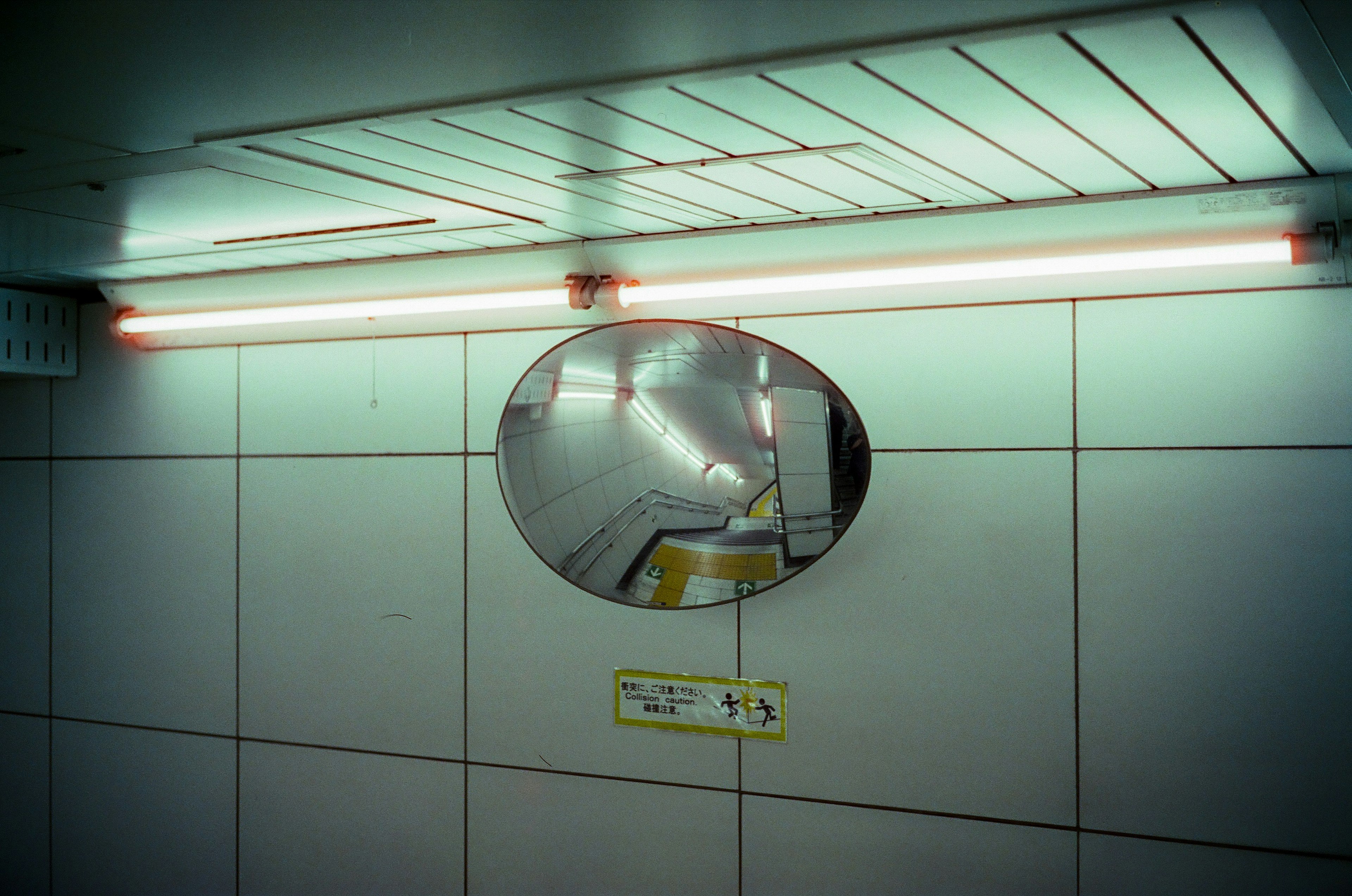 U-Bahn Spiegel, der Deckenlichter und geflieste Wand reflektiert