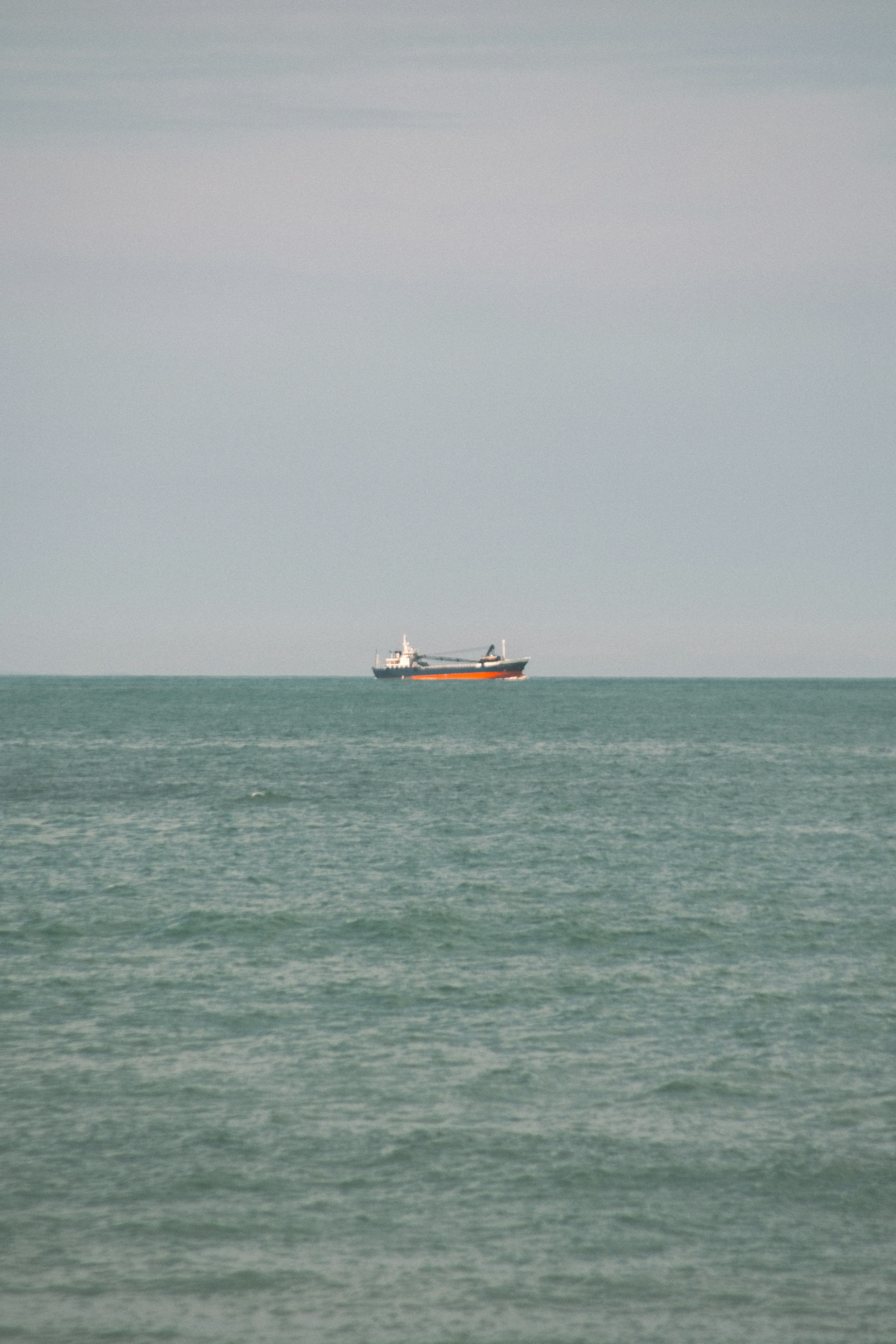 Cargo ship floating on the sea with blue water