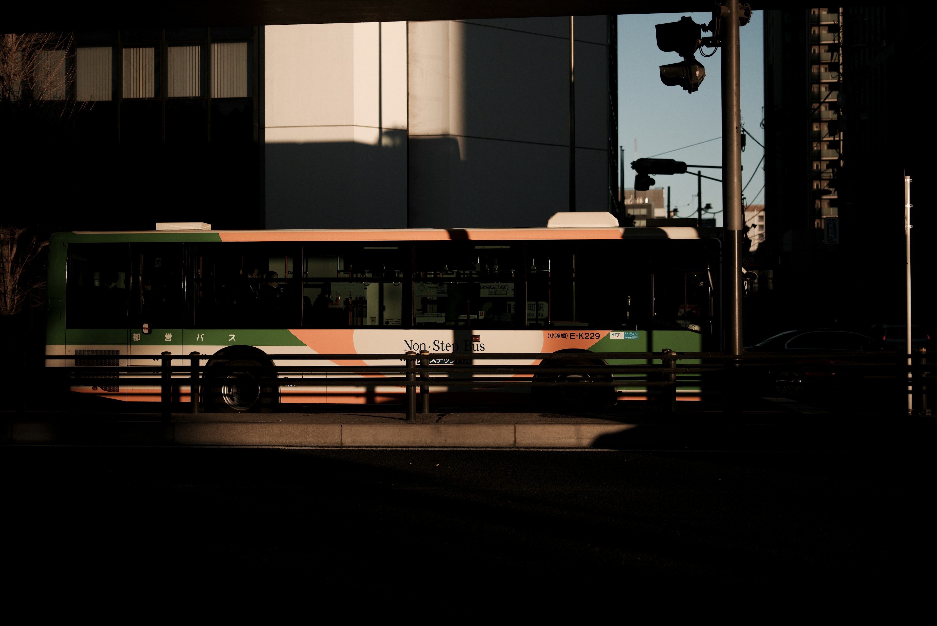 A bus parked in a dark setting with urban elements