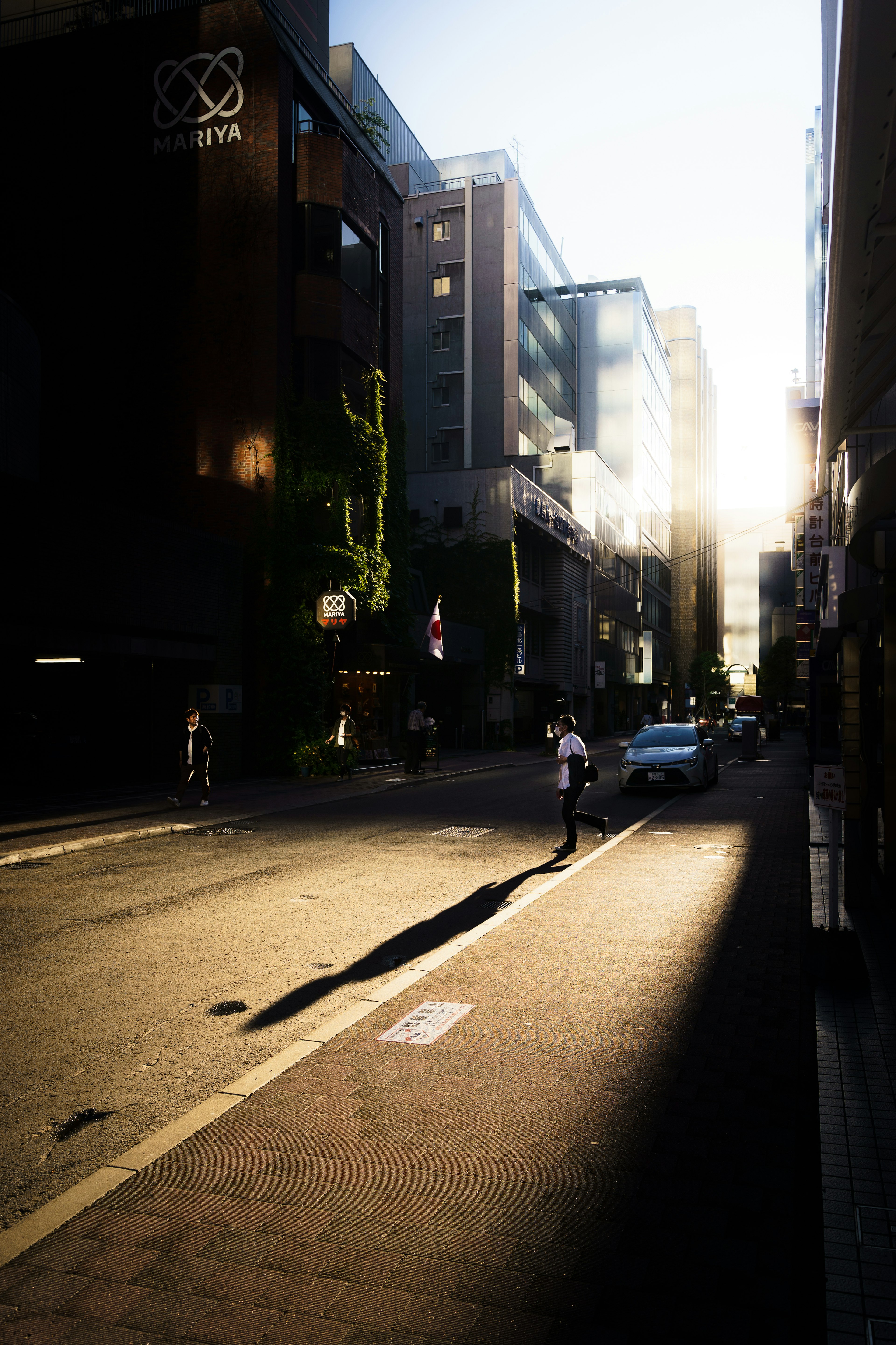 Escena de calle al atardecer con personas caminando