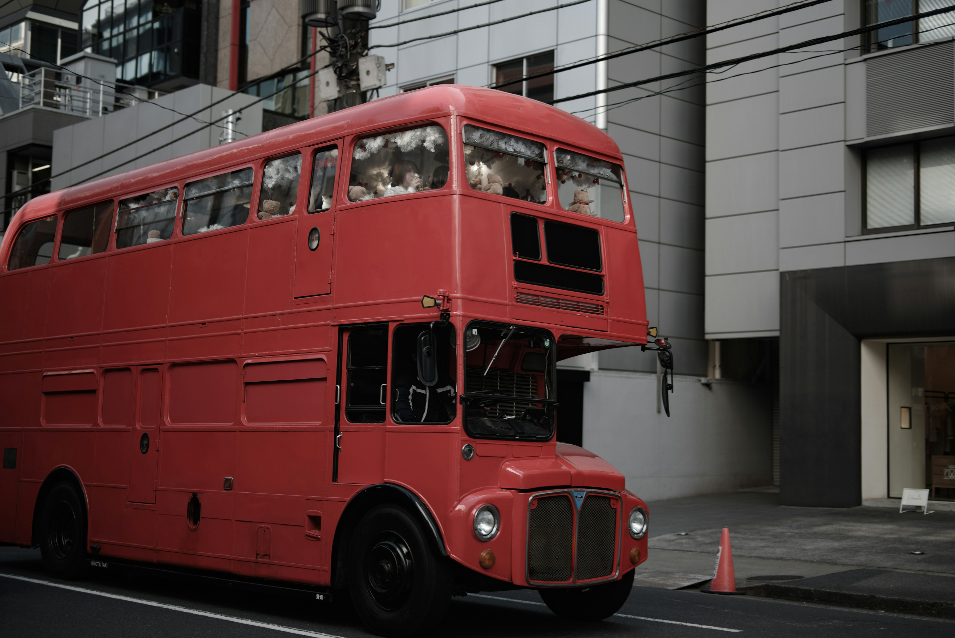 A red double-decker bus parked on an urban street