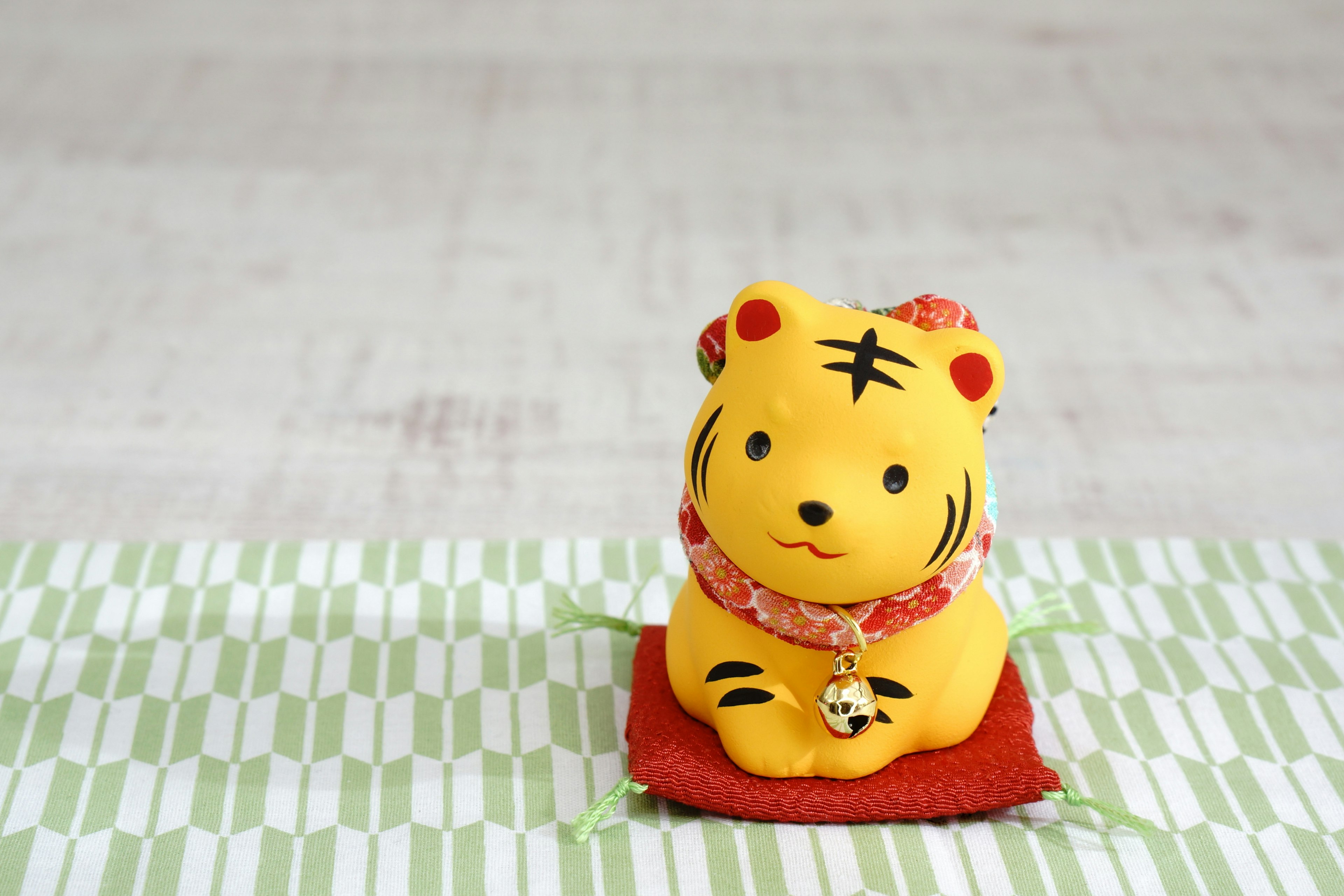 Une figurine de tigre jaune assise sur un tapis rouge