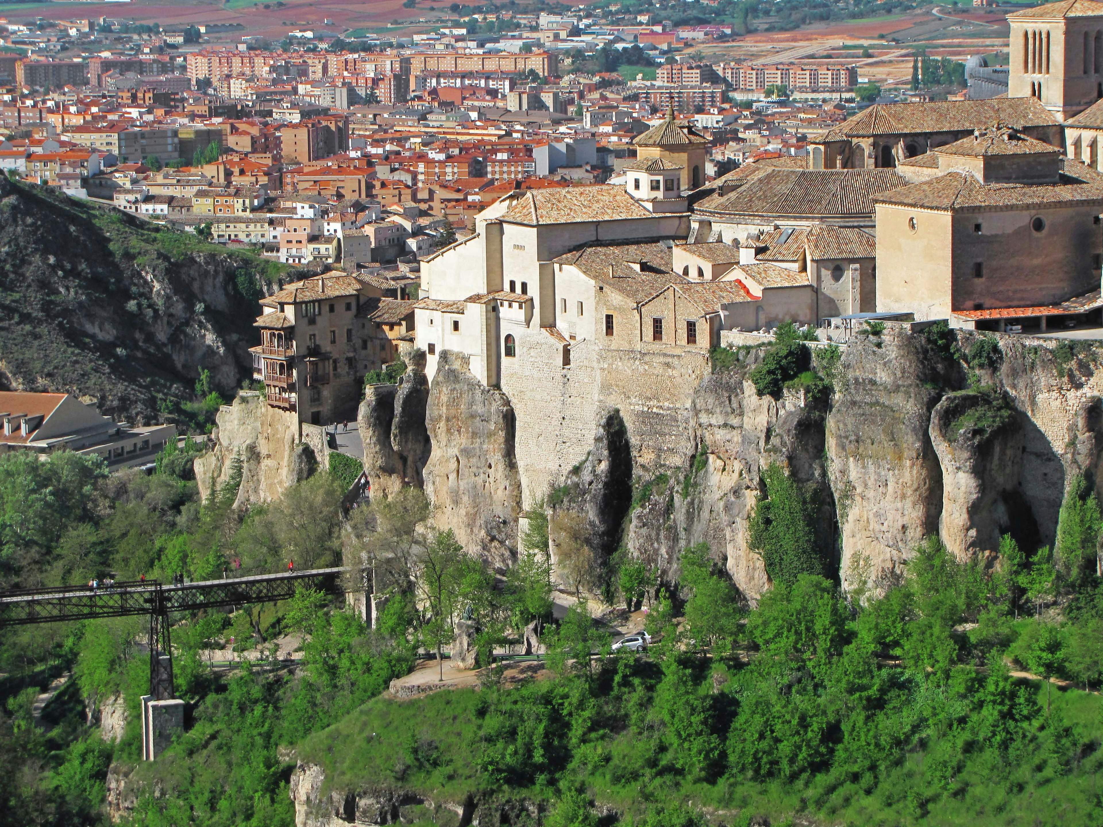 Scenic view of old buildings on a cliff with green landscape and a town in the background