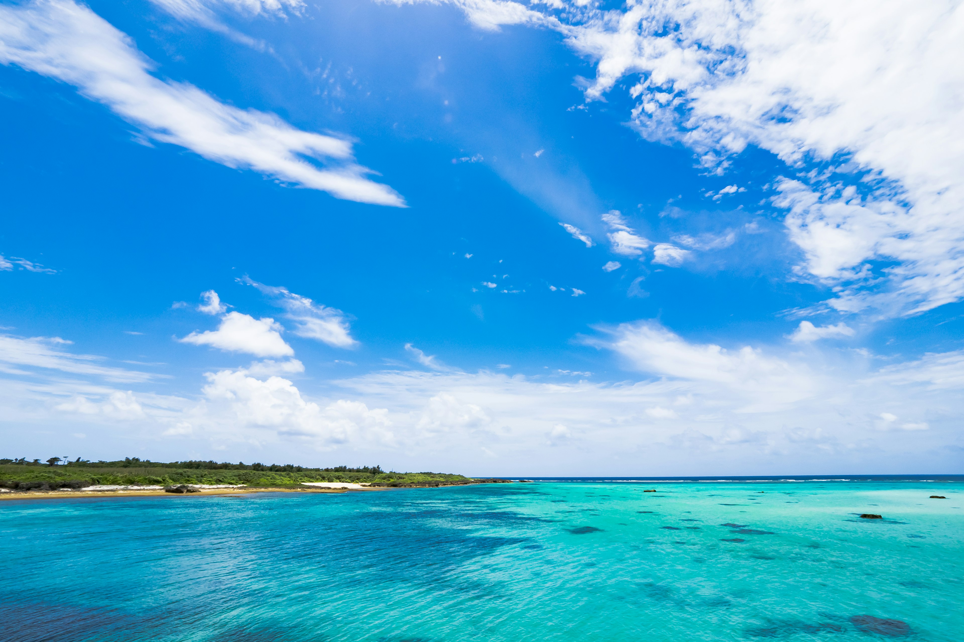 A beautiful landscape featuring a blue sky and clear turquoise water