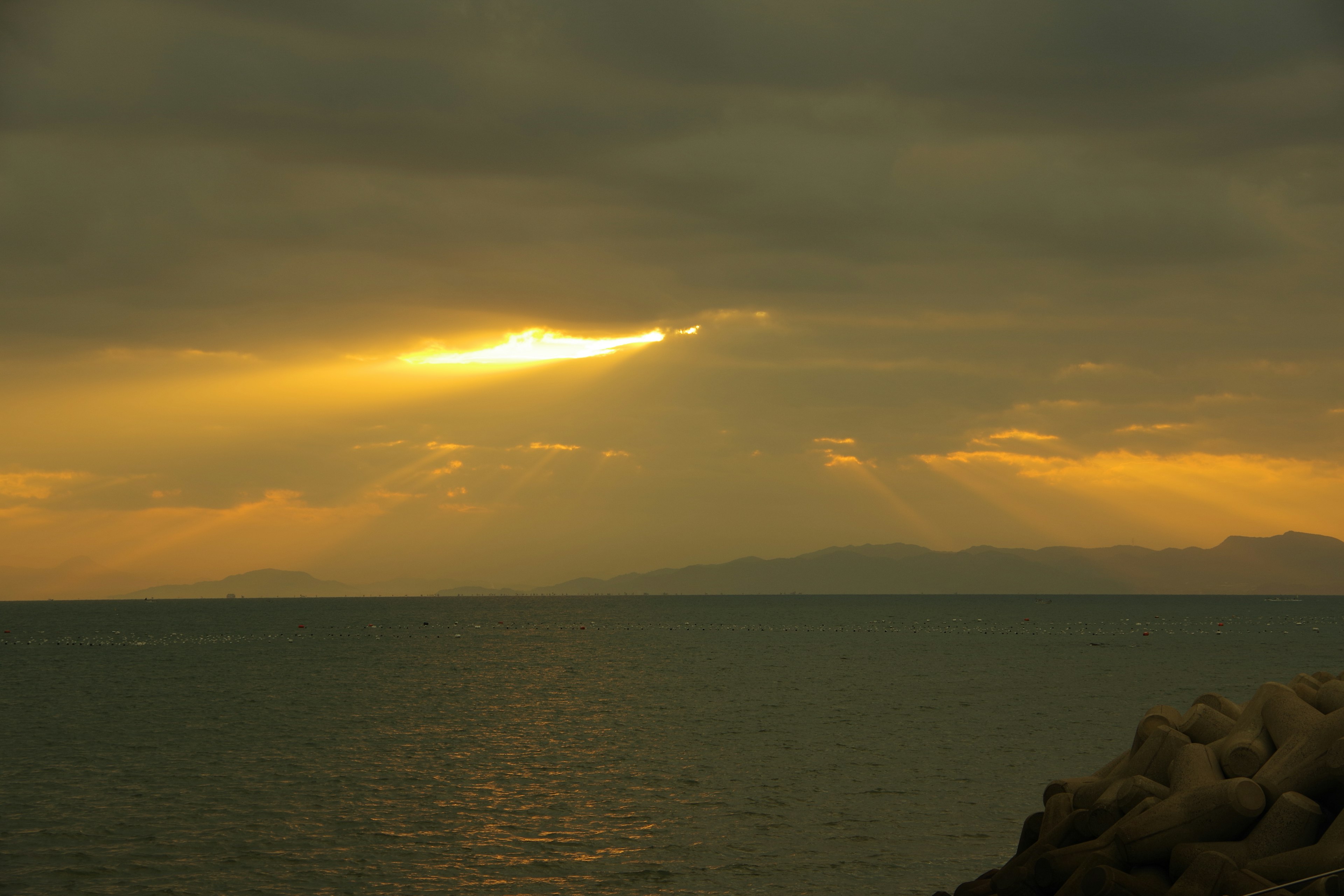 Sonnenlicht, das durch Wolken über dem Meer bricht