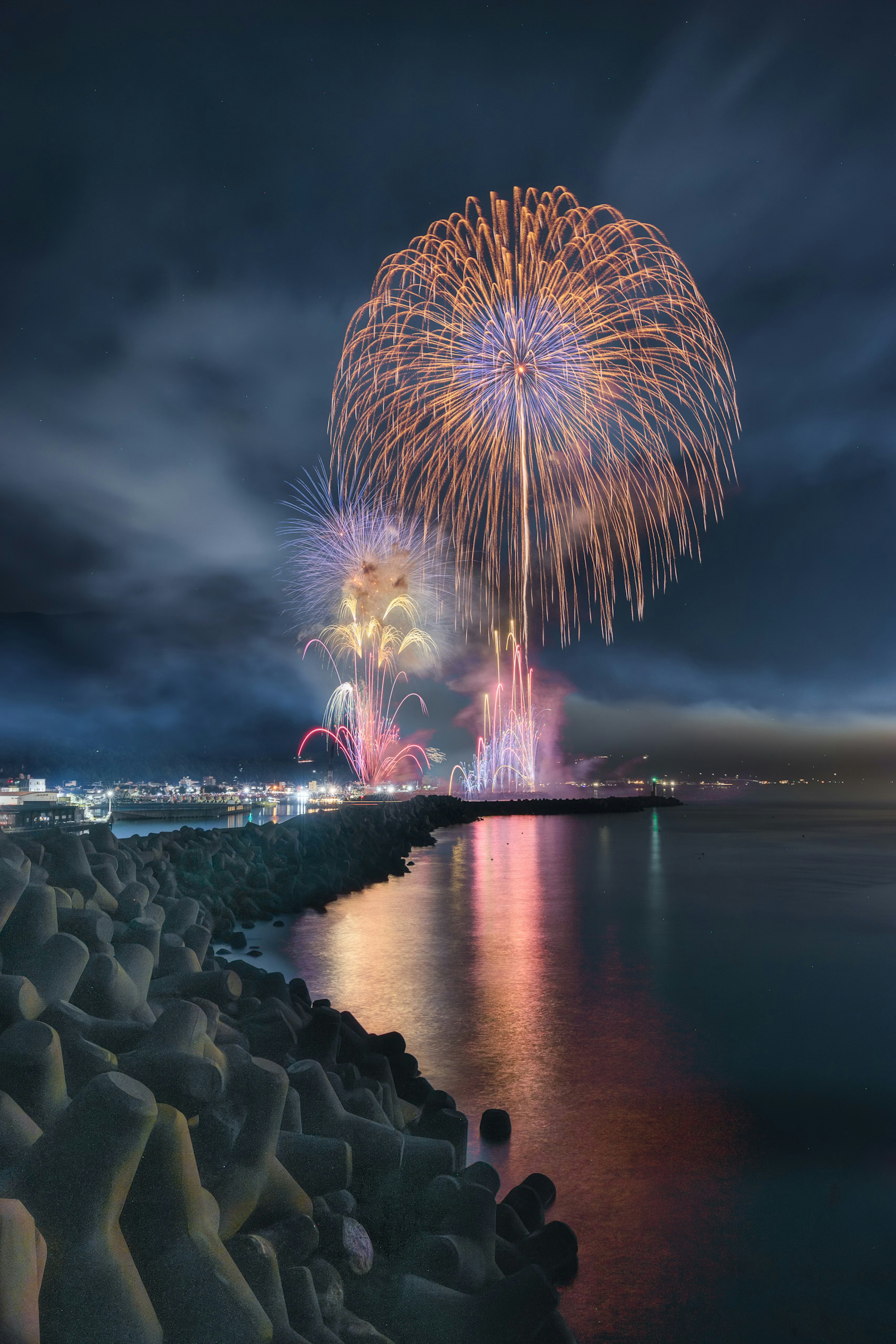 色彩缤纷的烟花照亮平静海面上的夜空