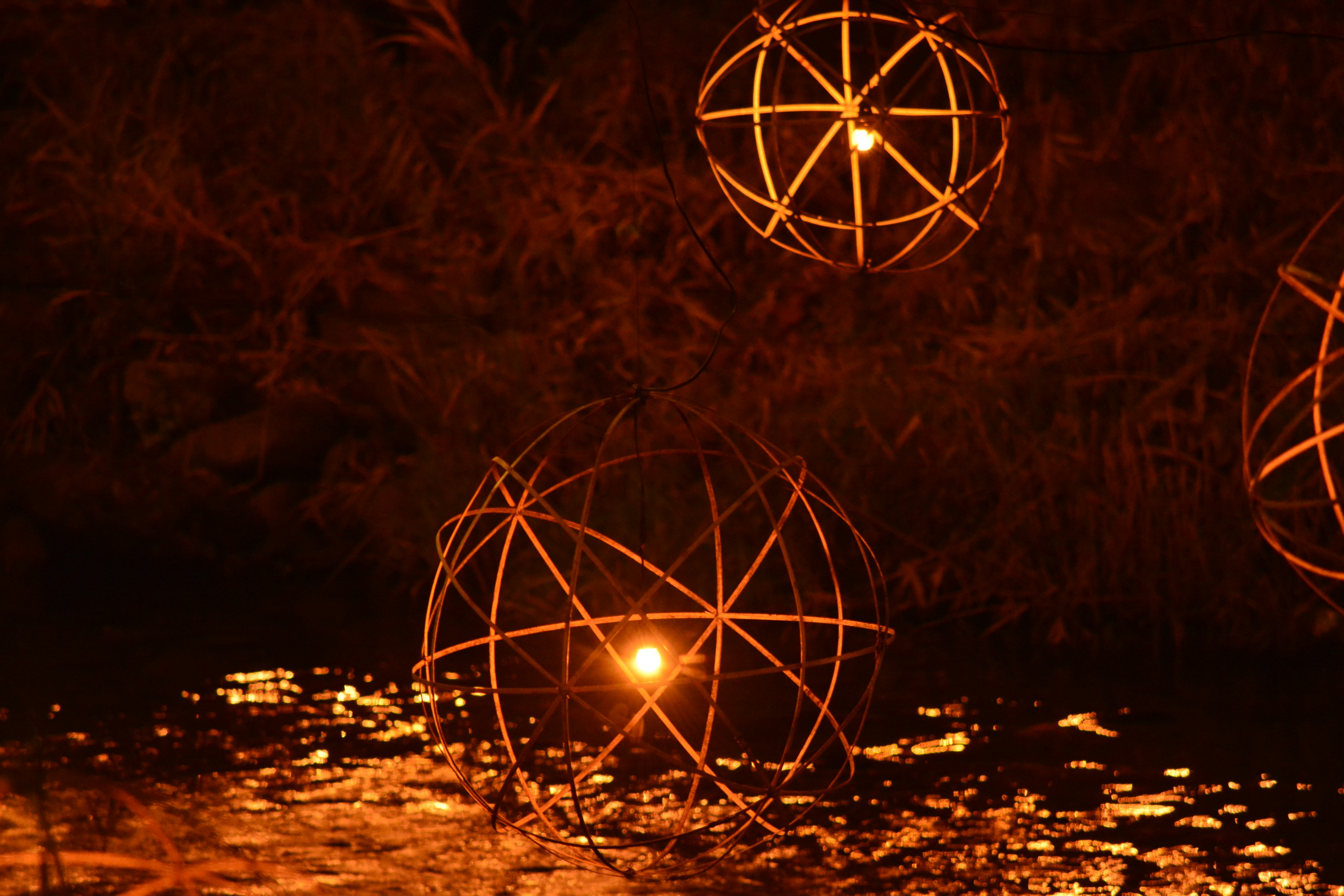 Objetos esféricos brillantes flotando sobre el agua con un fondo oscuro