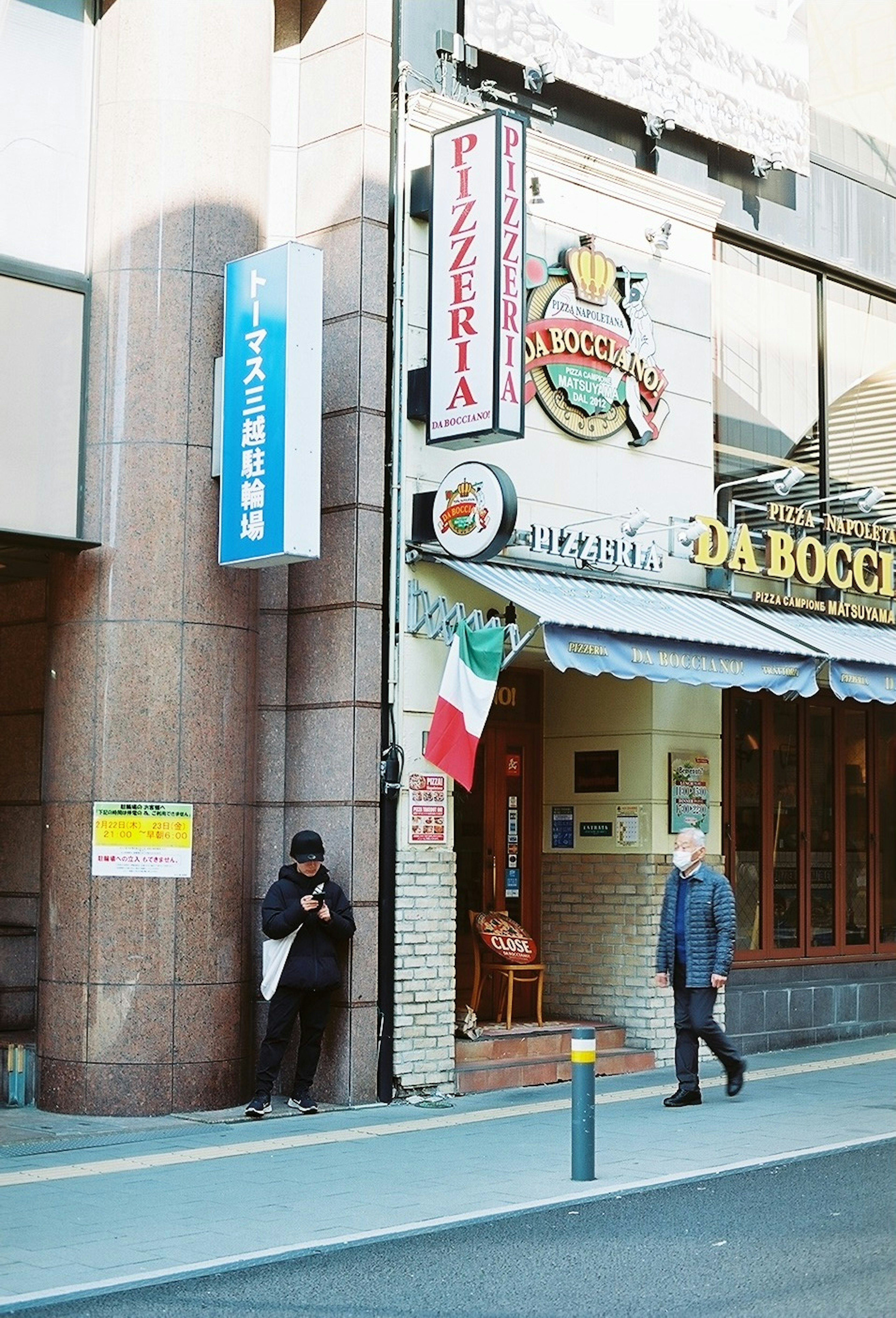 Straßenansicht mit der Pizzeria Da Boccia und einem Passanten