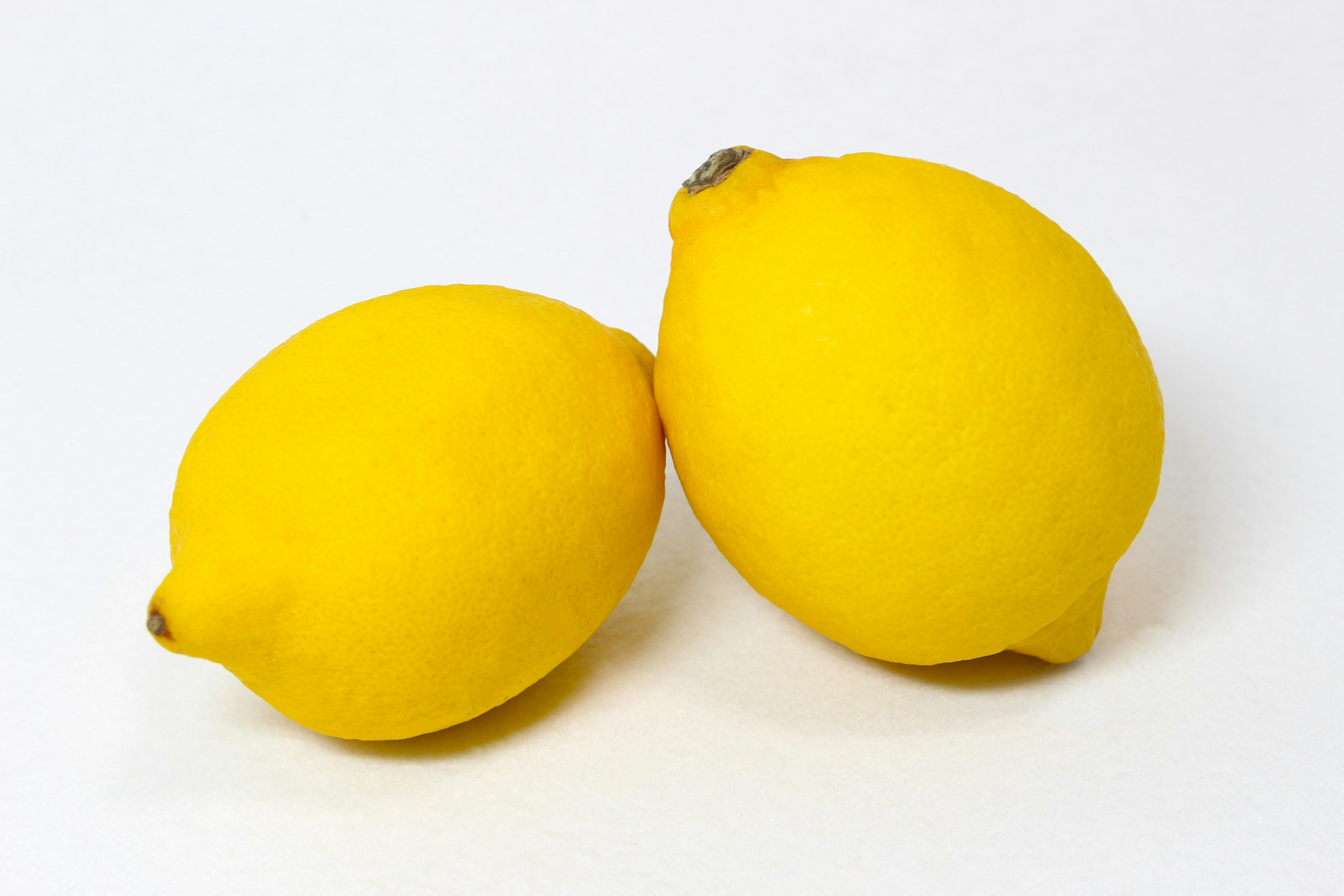 Two yellow lemons placed on a white background