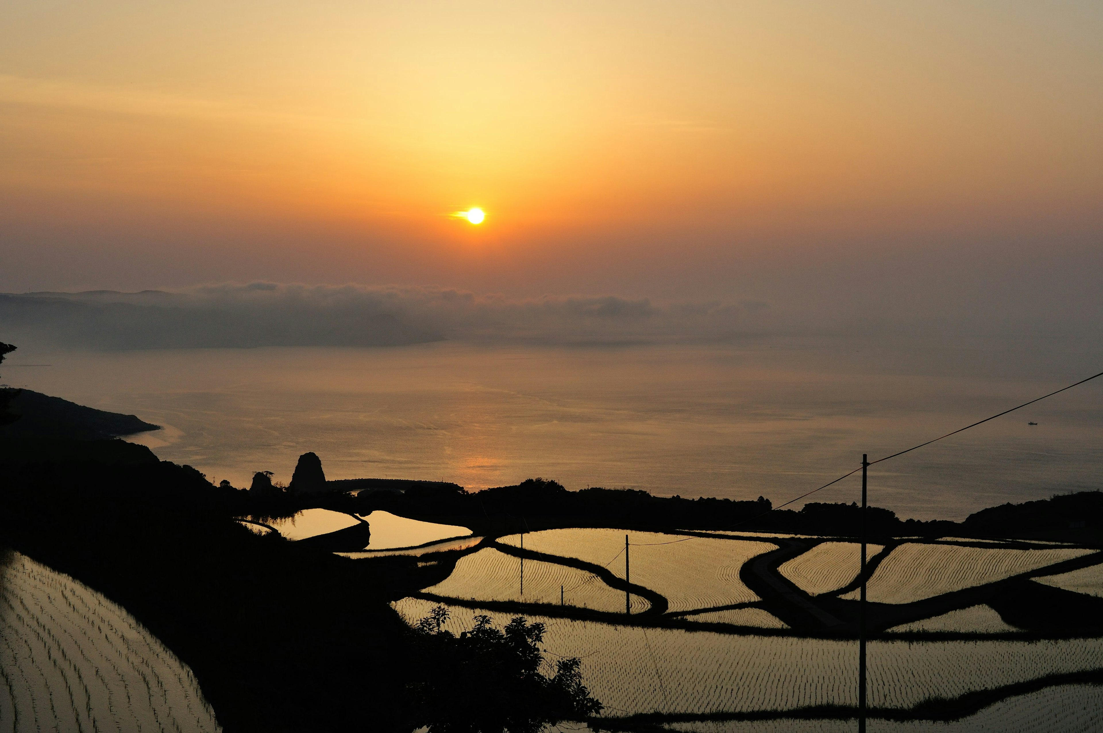 美しい夕日が海に沈む景色と水田の風景