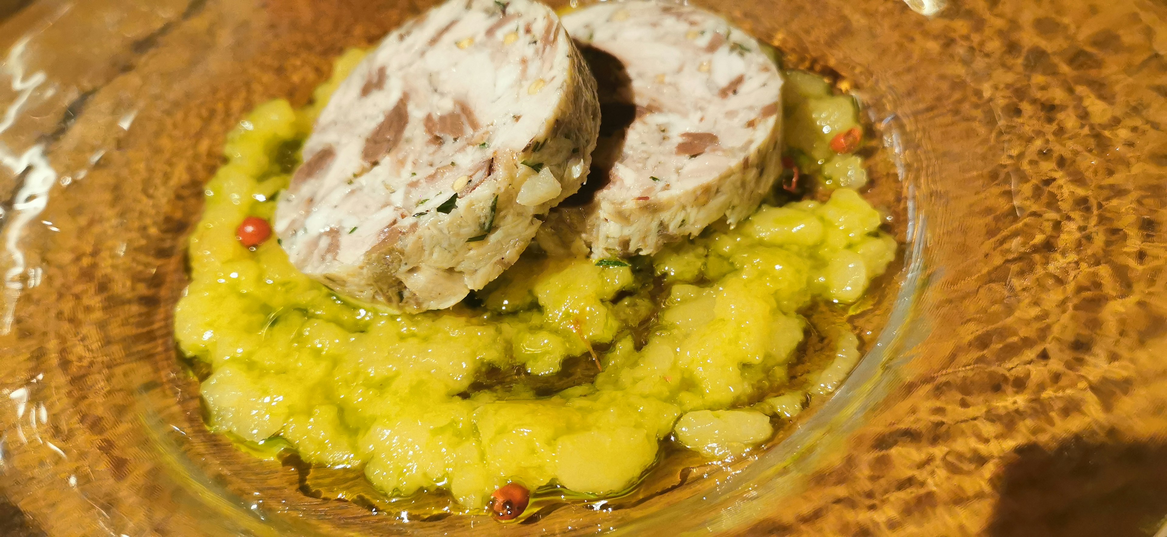 Plato de carne en rodajas servido sobre puré de patatas con una presentación colorida