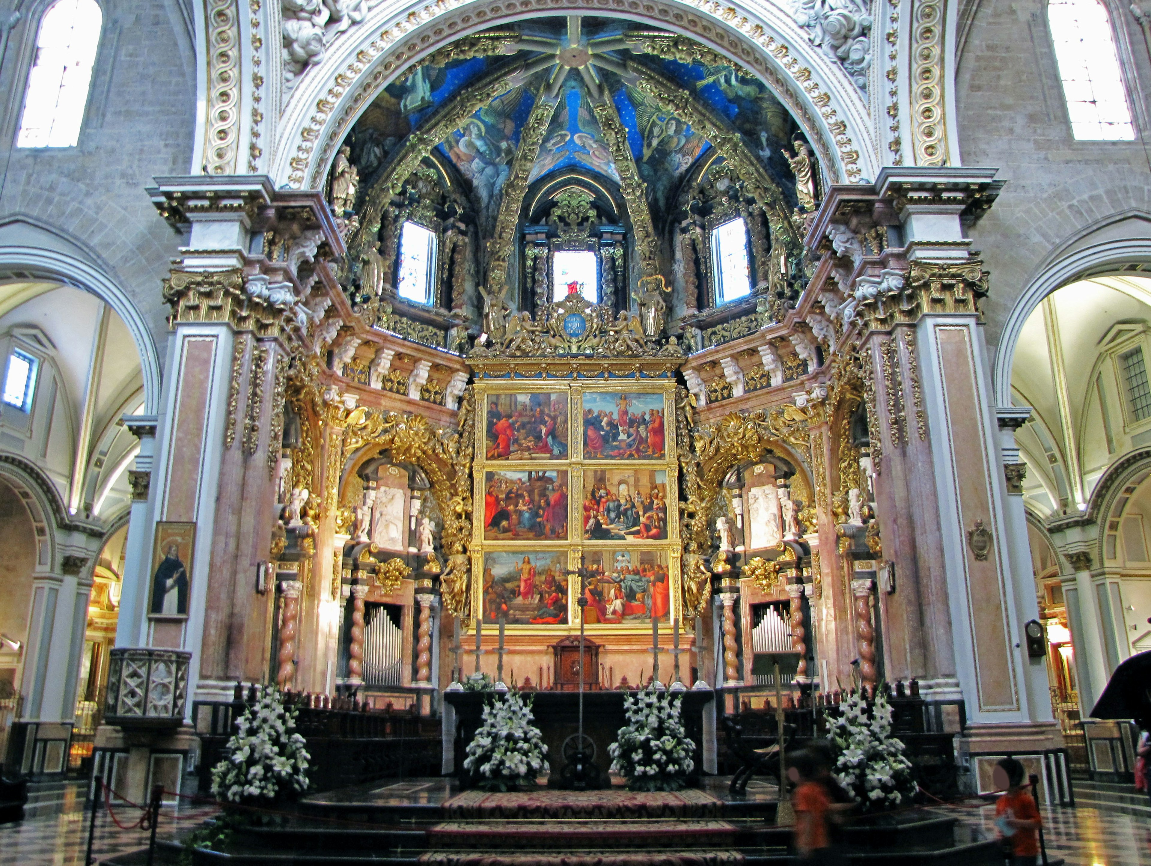 Interno di una bellissima chiesa con un altare decorativo e un soffitto blu vibrante, intagli dorati e dipinti