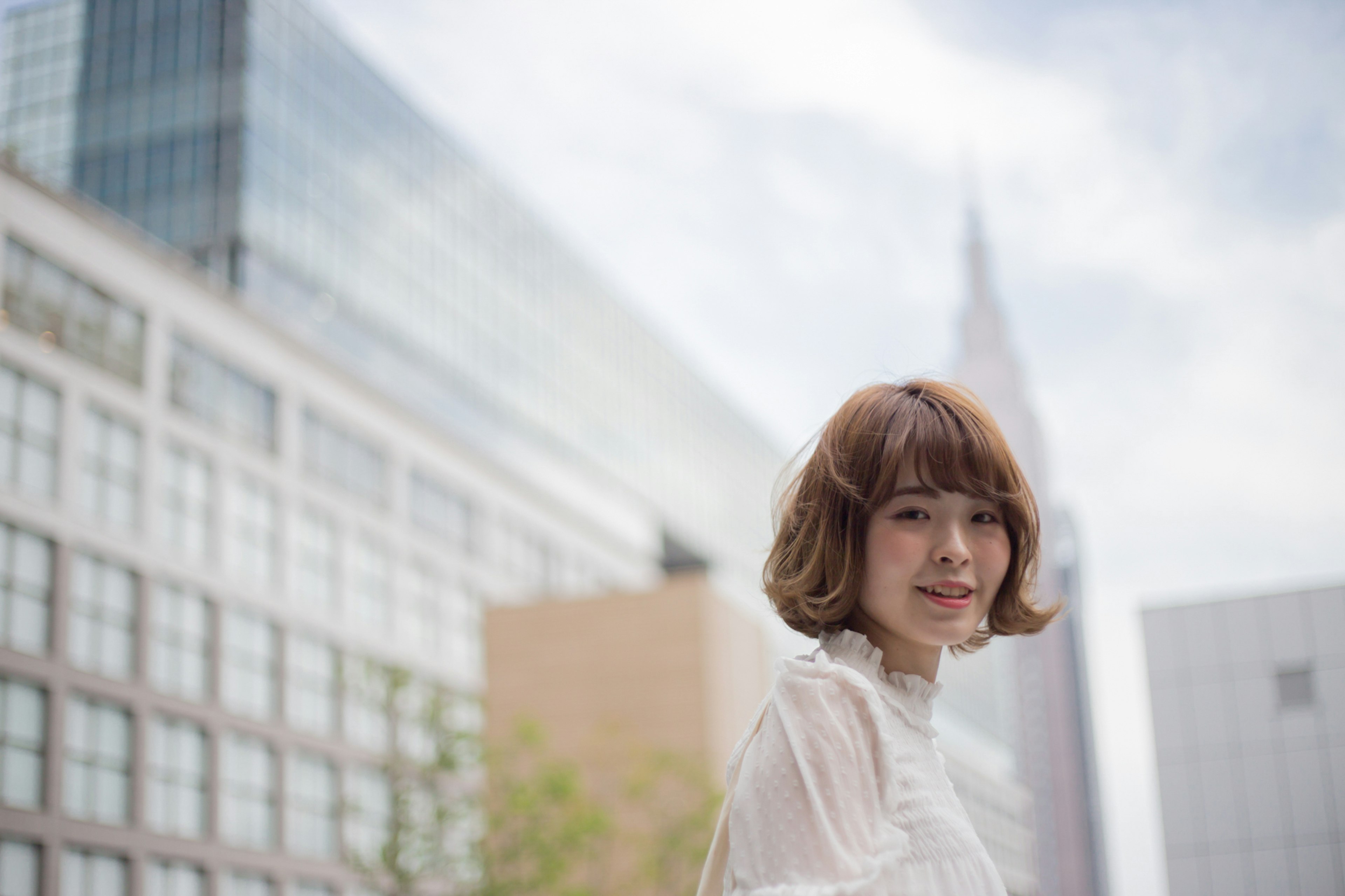 Portrait d'une femme souriante avec un arrière-plan urbain