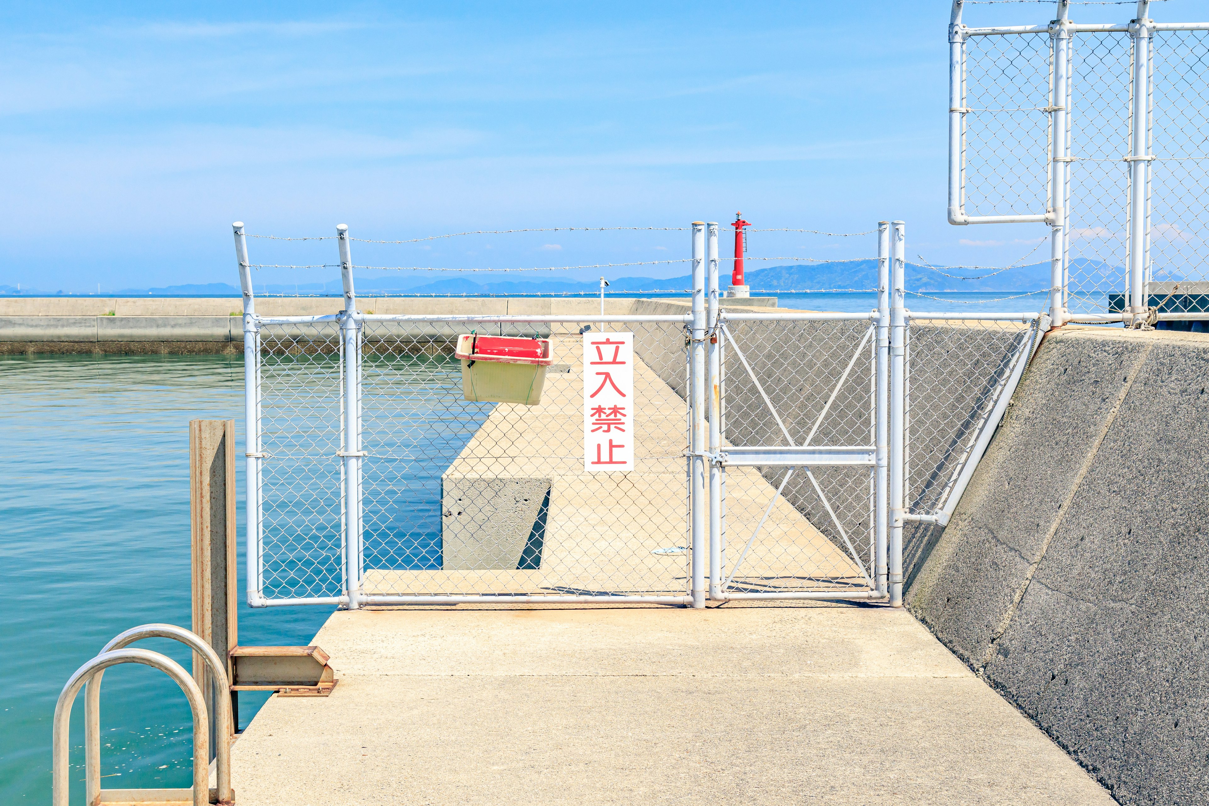 Muelle de concreto con entrada cercada que da al mar