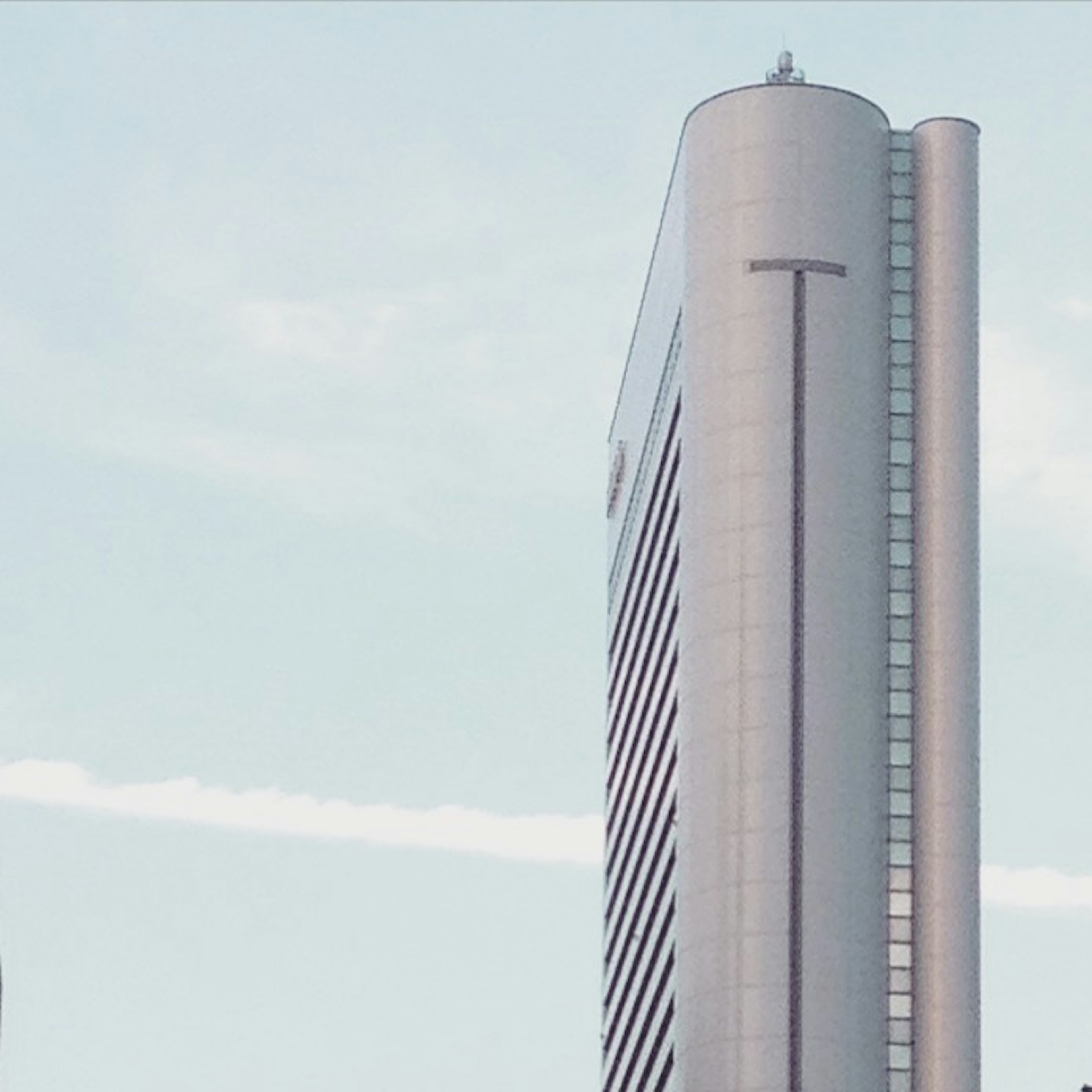 Primer plano de un rascacielos con cielo azul y nubes, diseño moderno