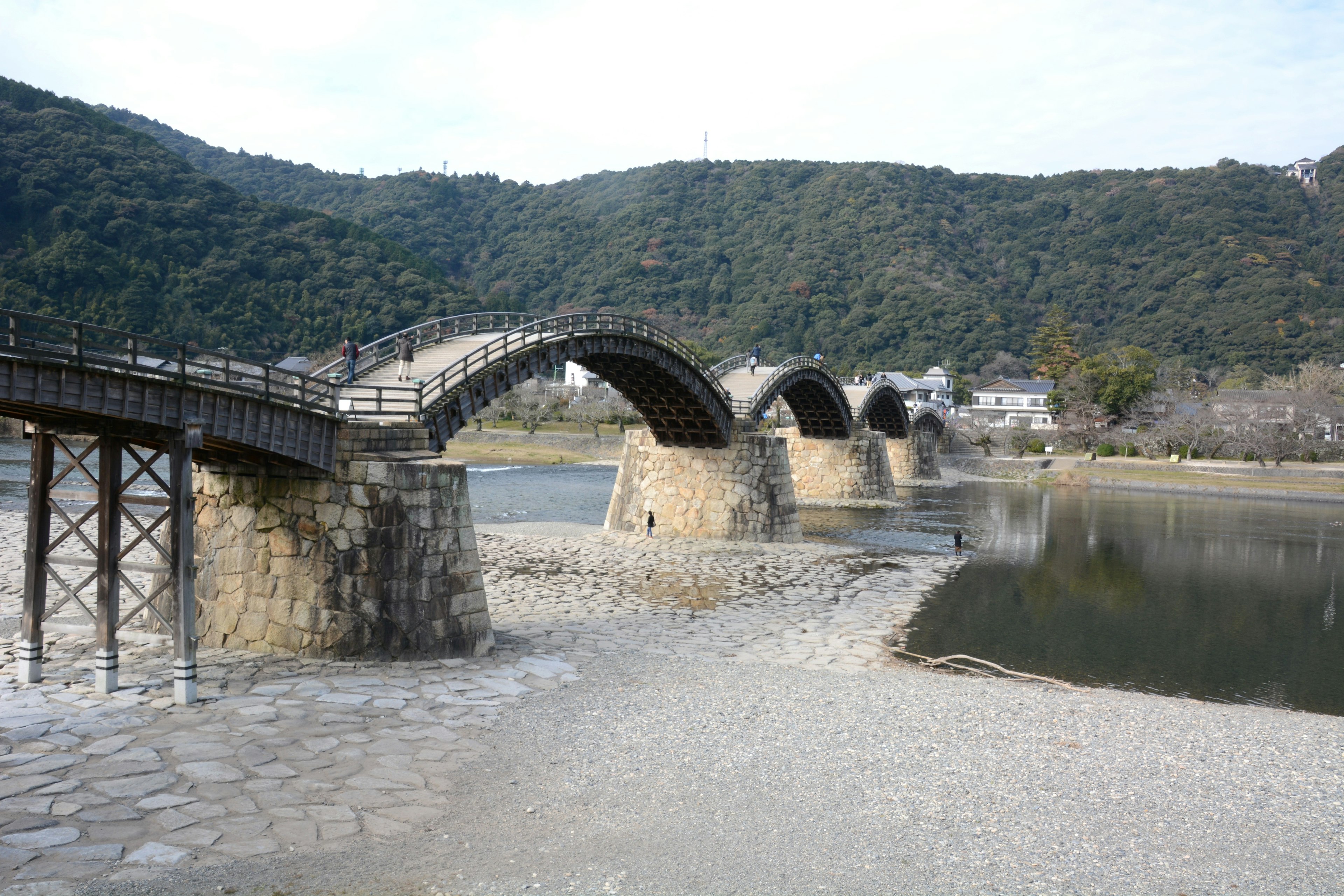 美しいアーチ型の橋が山の背景にかかる風景