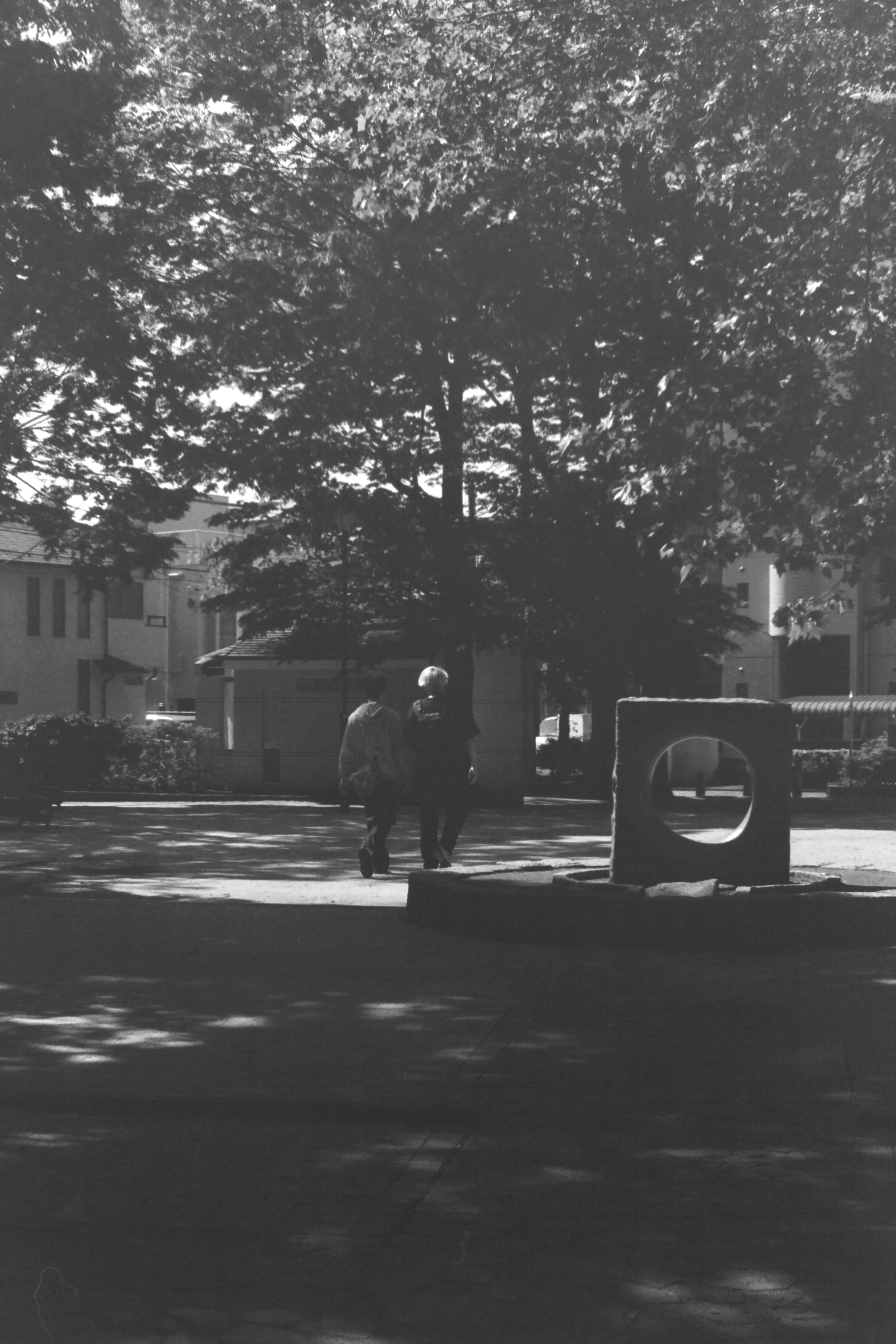 Photo en noir et blanc avec une personne debout sur fond urbain