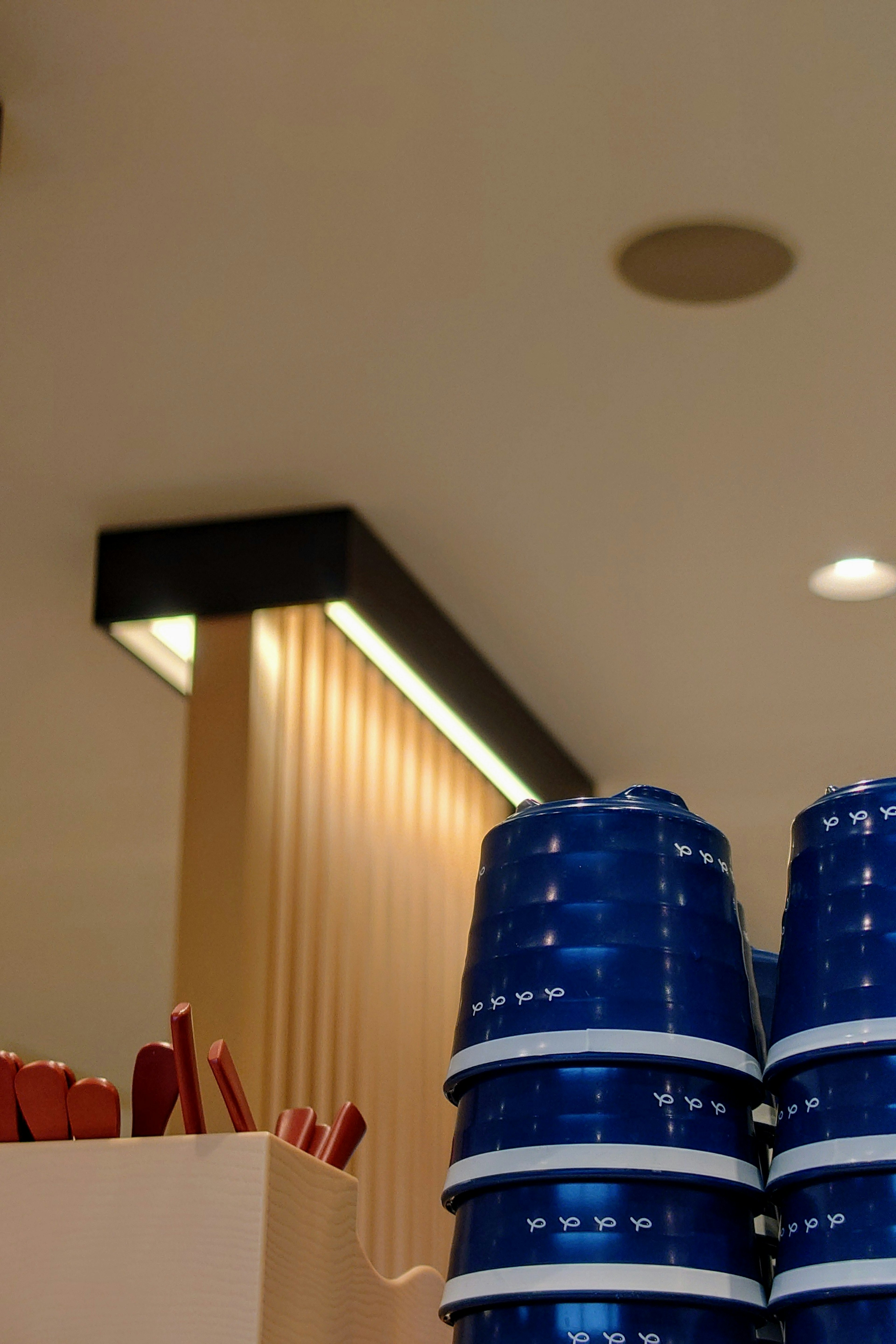 Montón de tazas azules en el interior de un café con acentos de madera