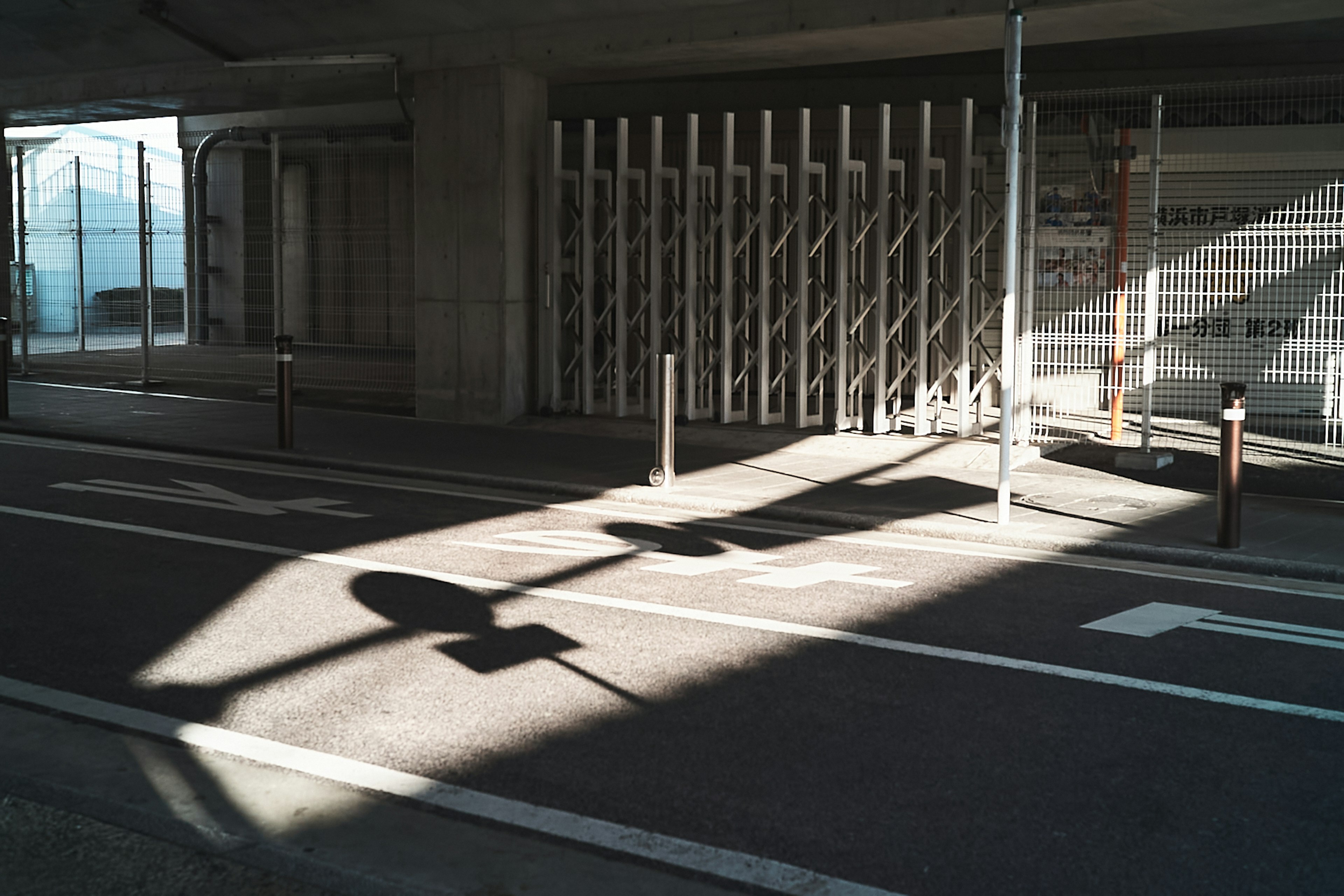 影が落ちた道路とフェンスの構造