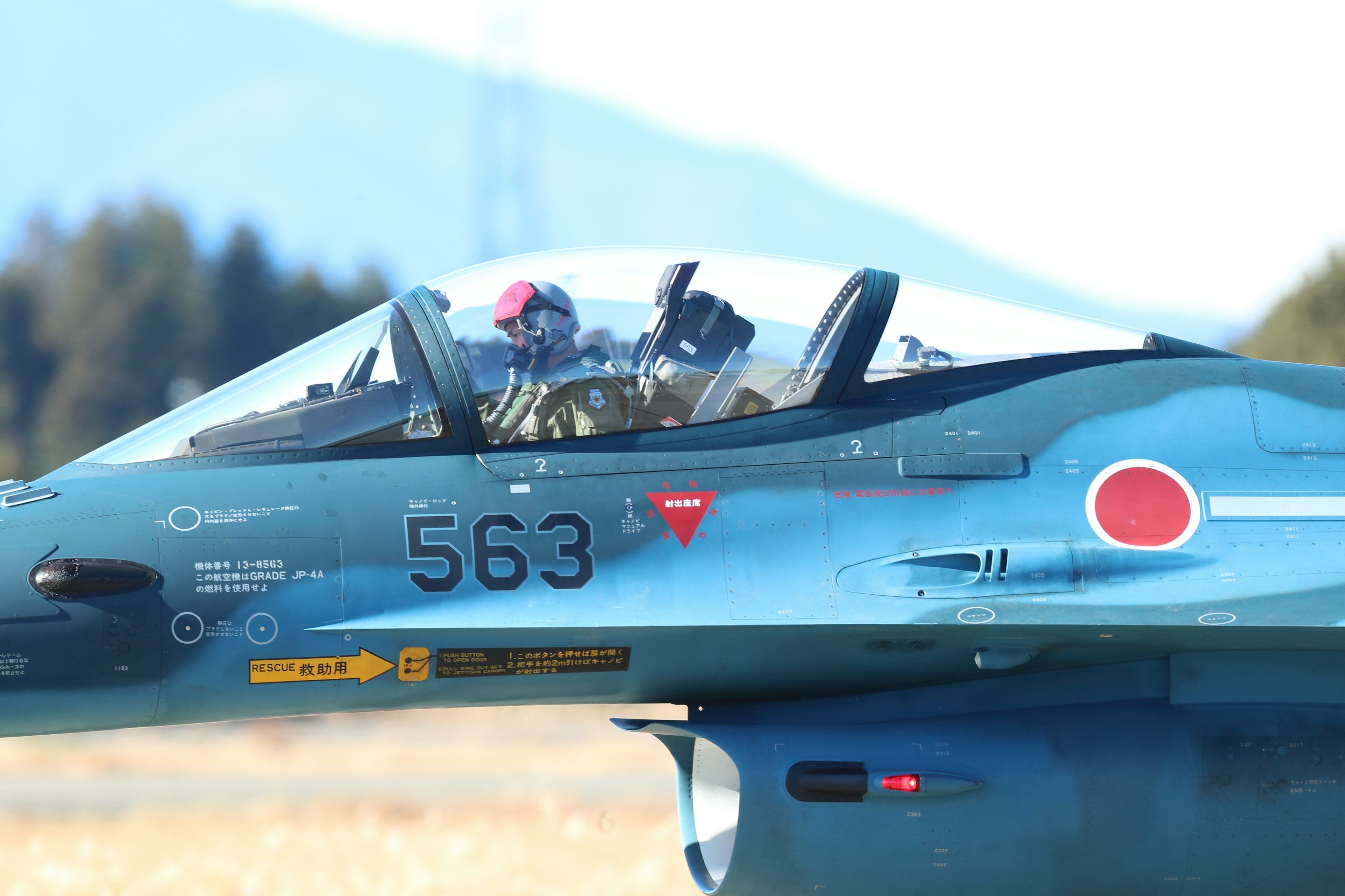 Close-up of a Japanese fighter jet cockpit with a pilot inside