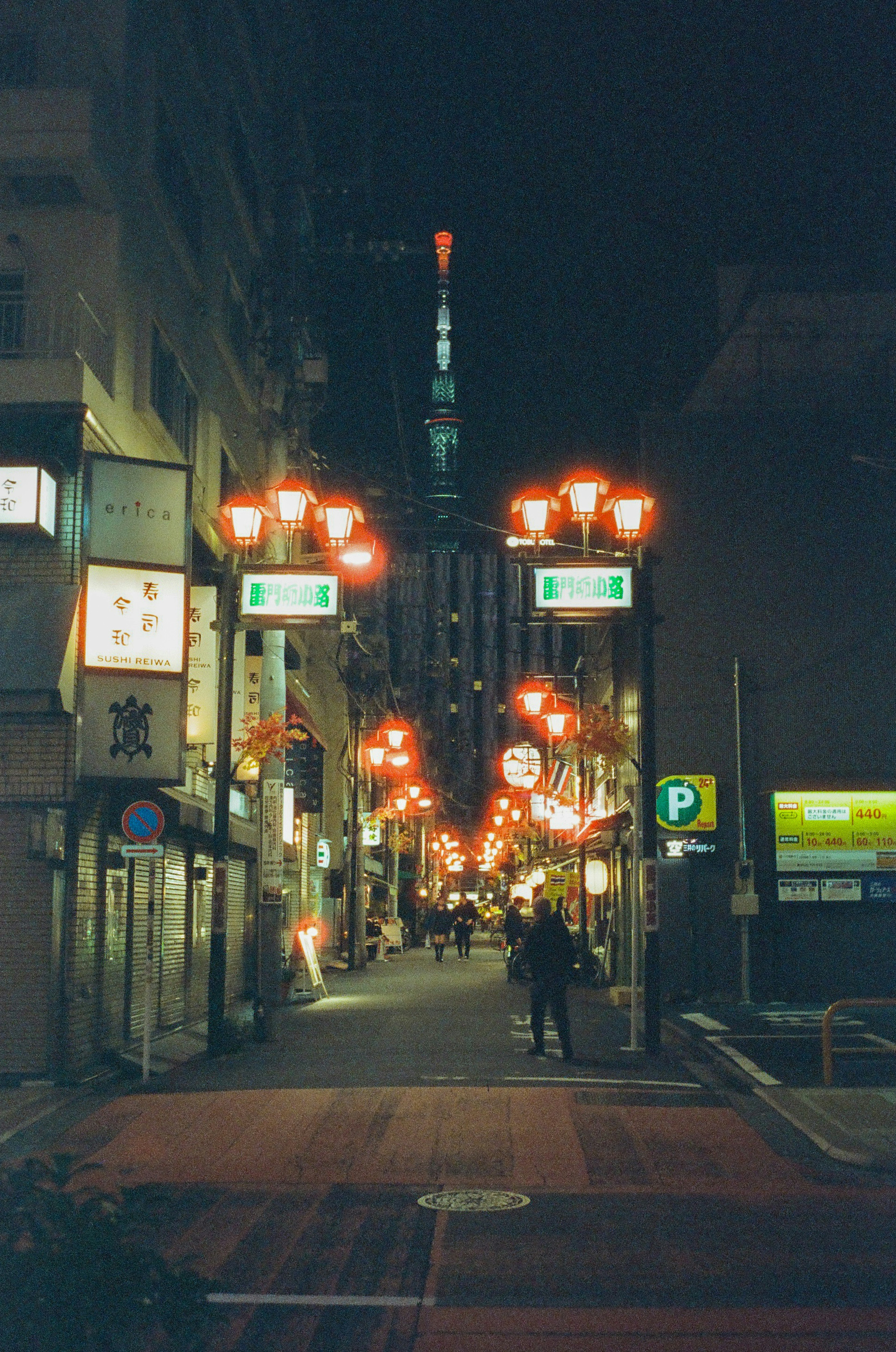 夜の都市通りに並ぶ赤いランプと東京タワーが見える風景