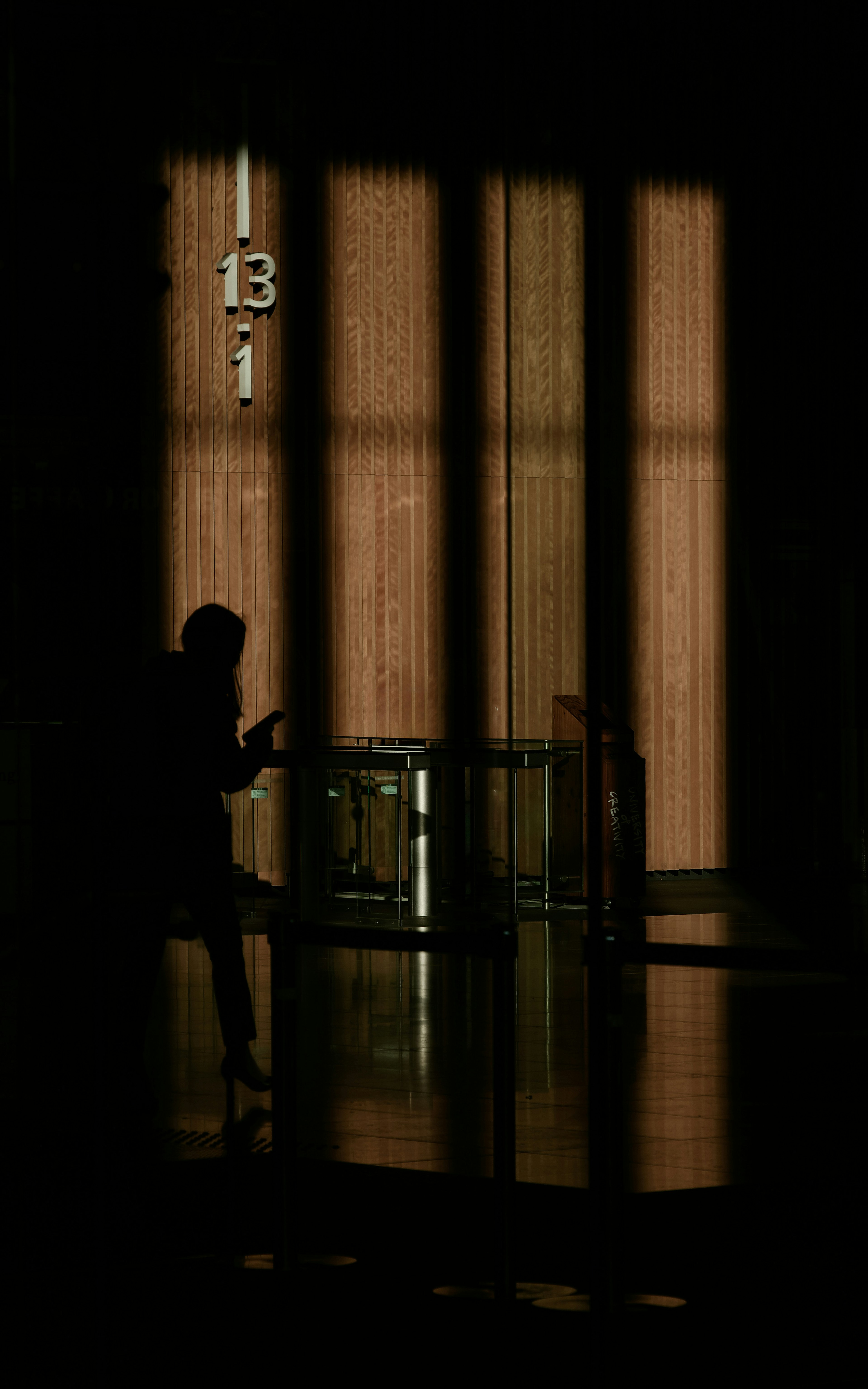 Silhouette d'une personne devant un mur en bois avec le numéro 13