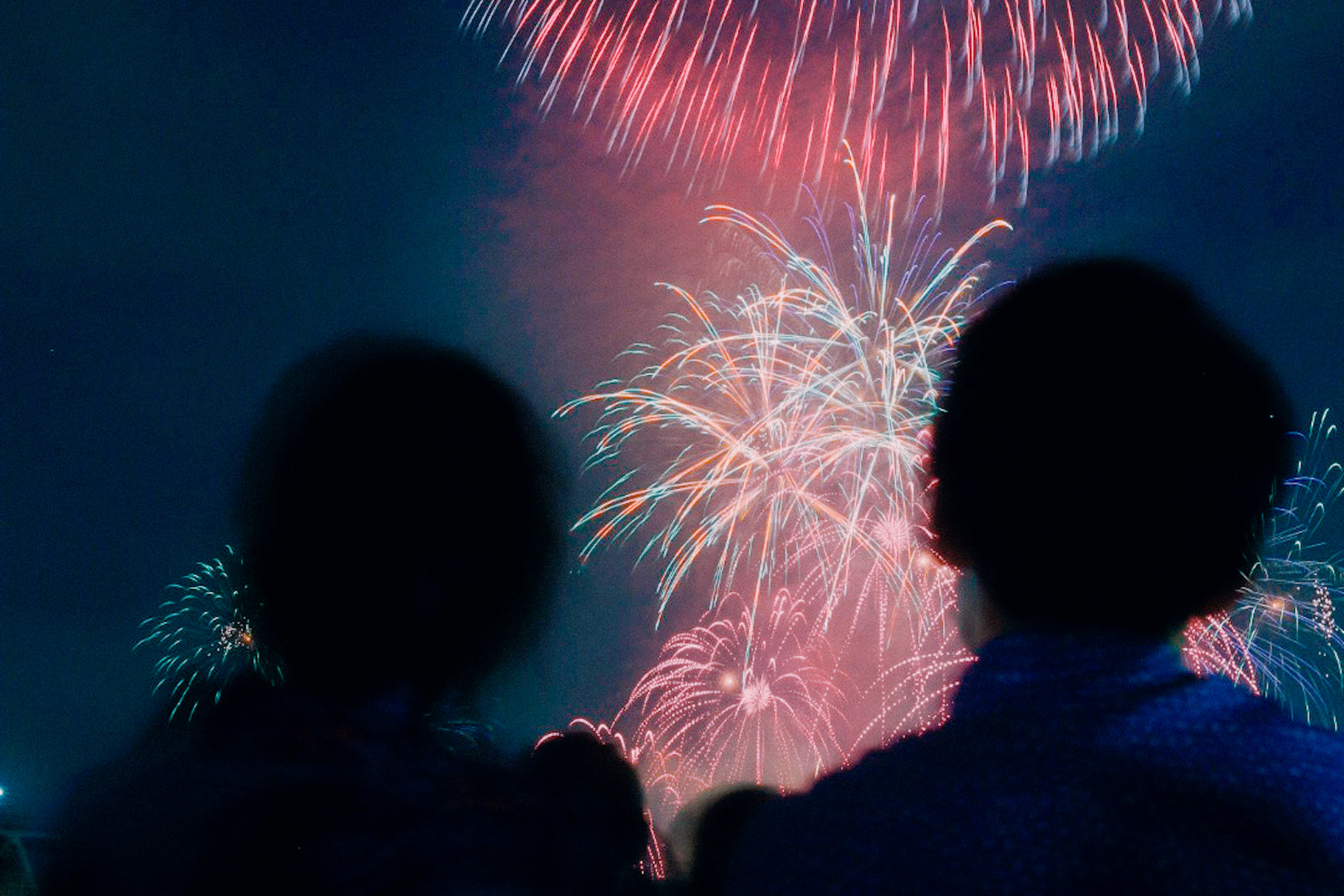 Two people watching fireworks in the night sky