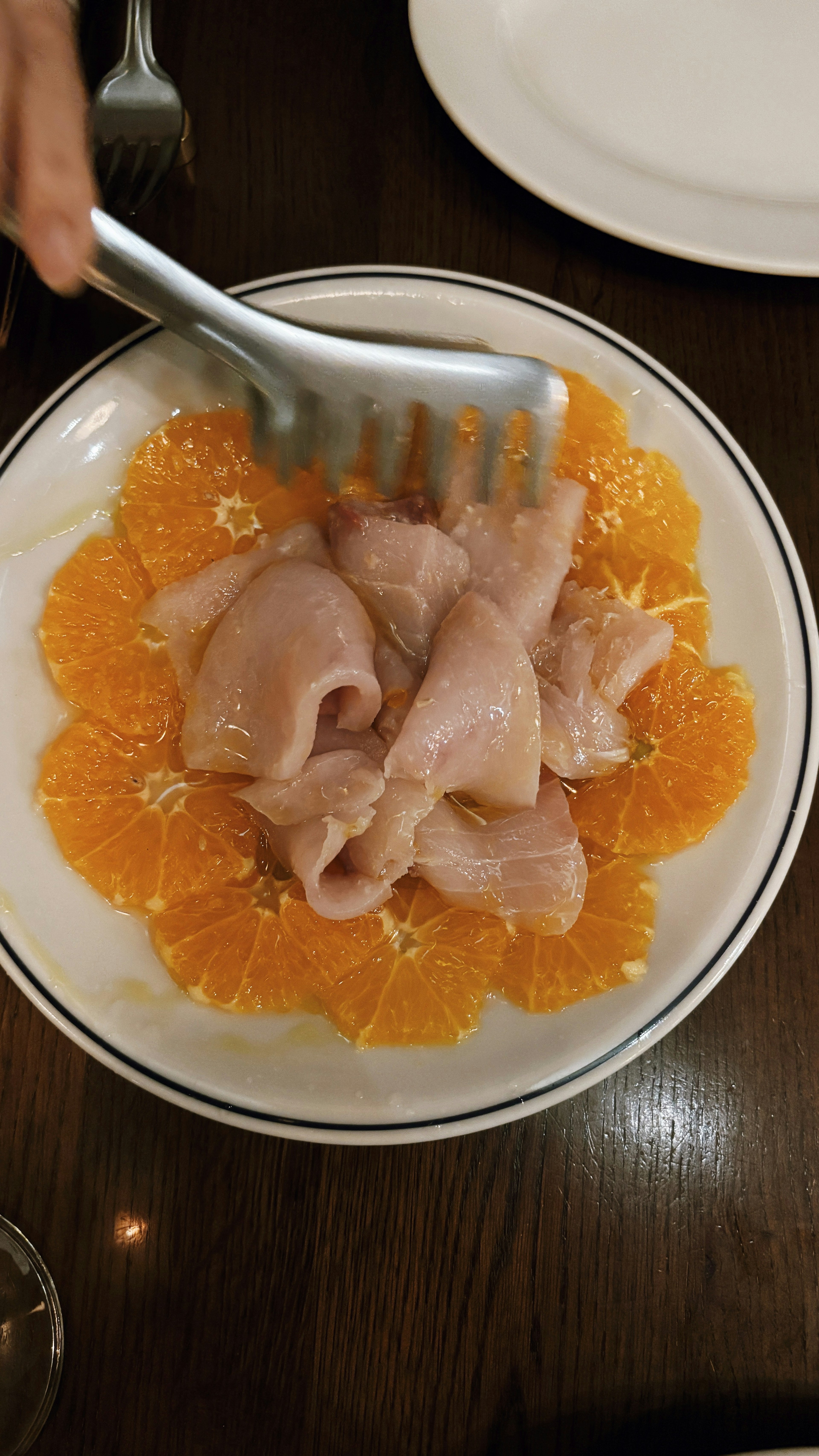 Plat de viande tranchée servi sur un lit d'orange