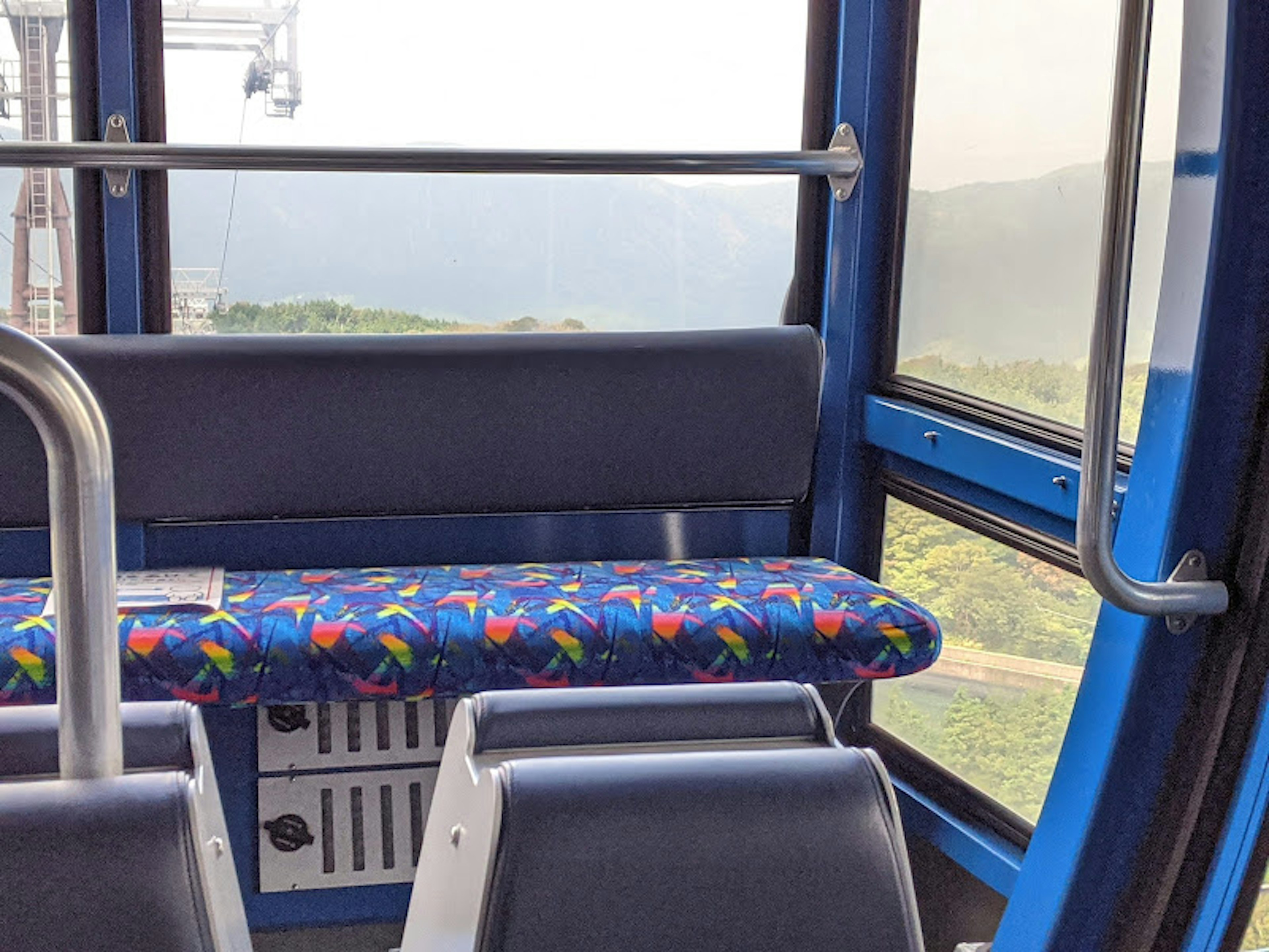 Interior of a gondola featuring colorful seating and a view through the window