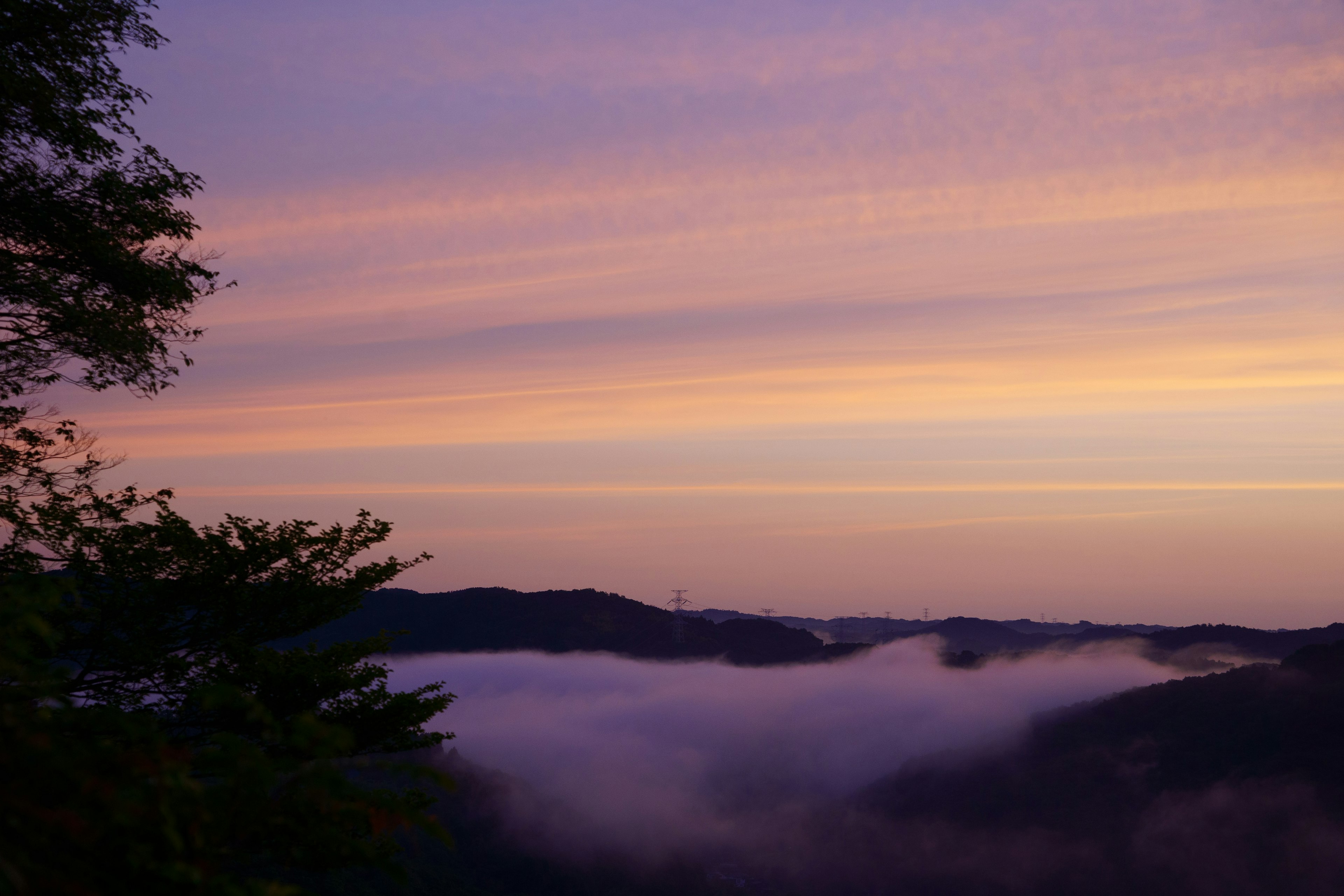 Pemandangan langit ungu di atas gunung berkabut