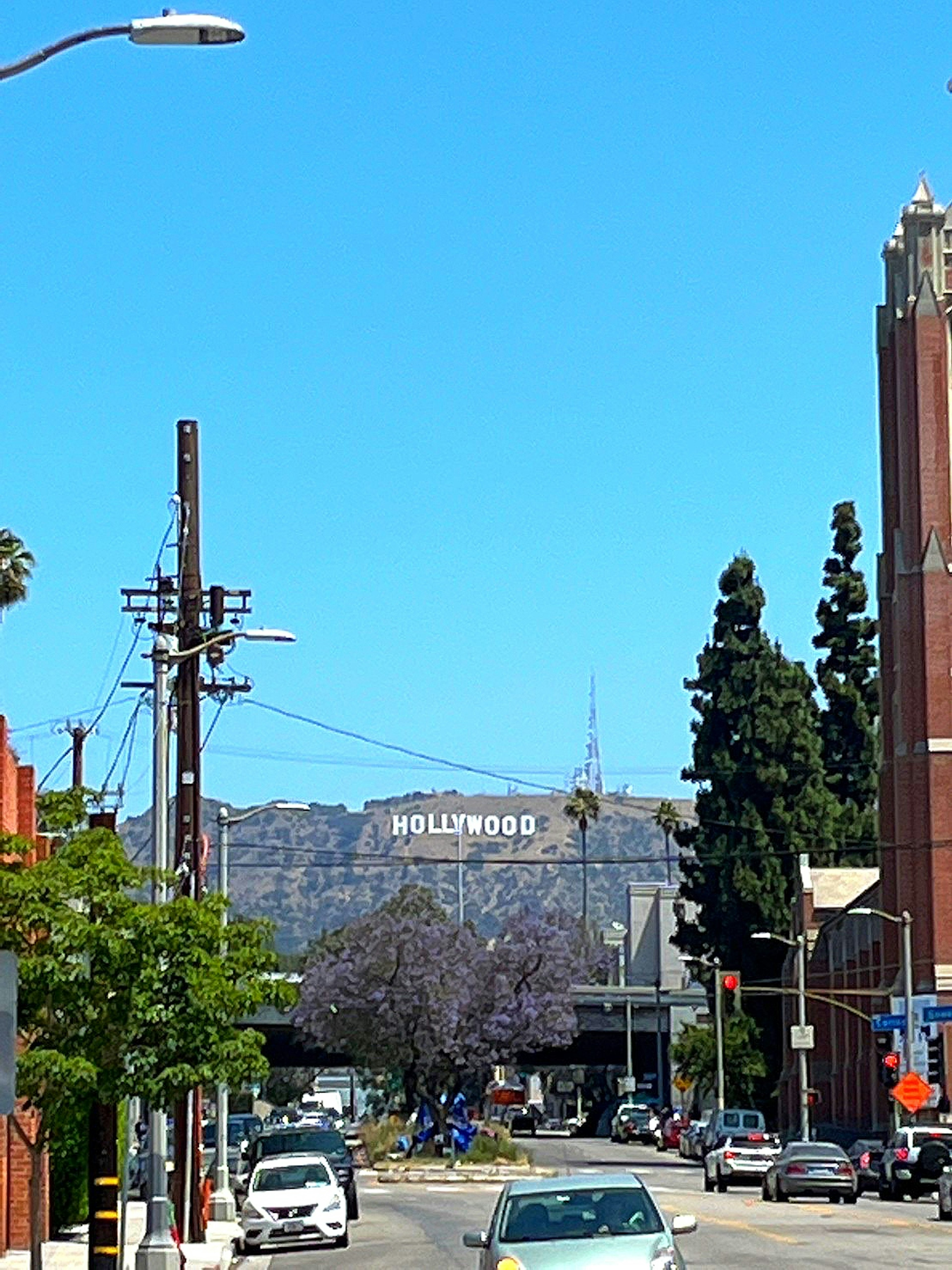 Blick auf das Hollywood-Schild mit Straßenszene und klarem blauen Himmel