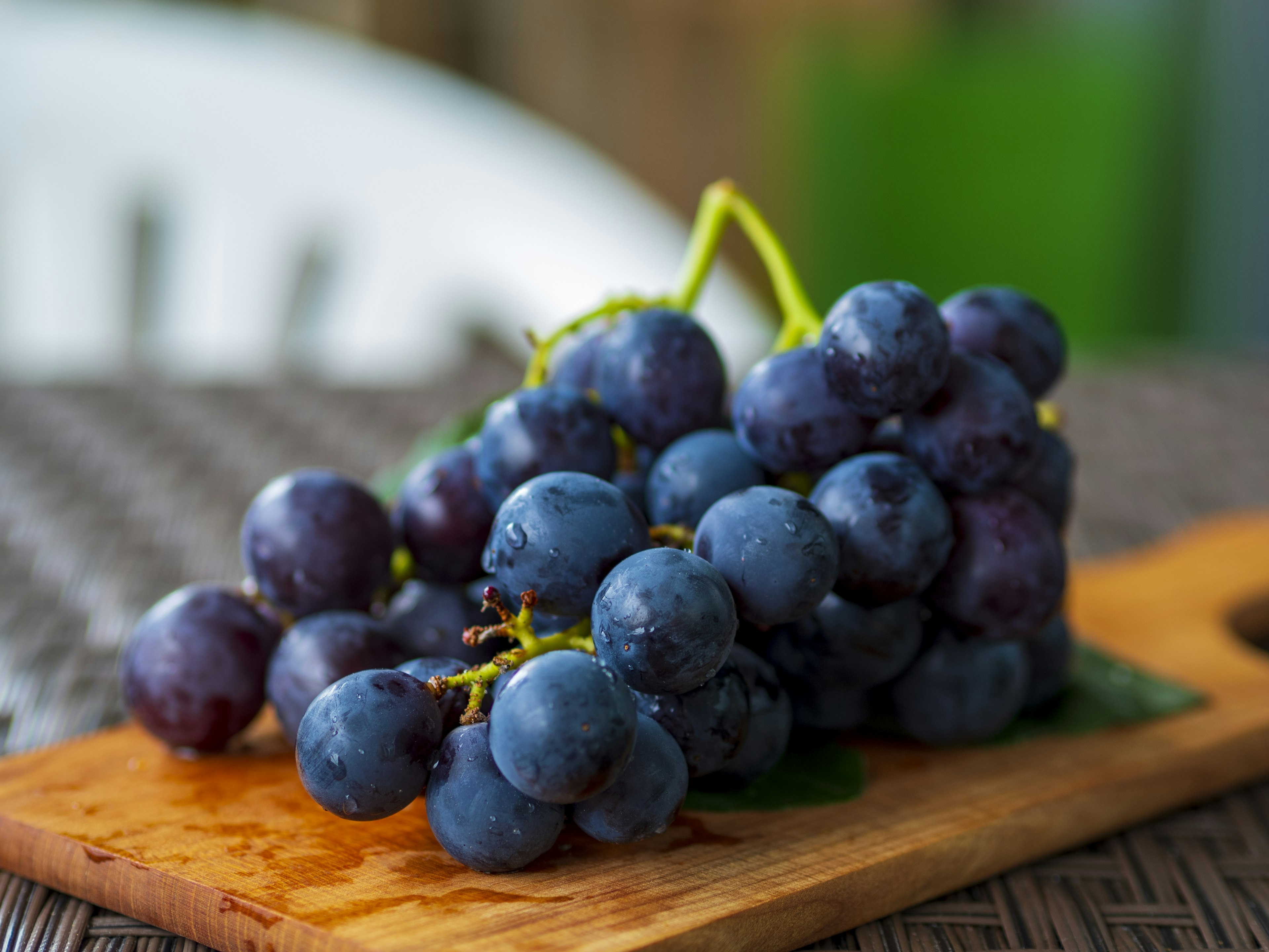 Racimo de uvas azules frescas dispuestas sobre una tabla de madera