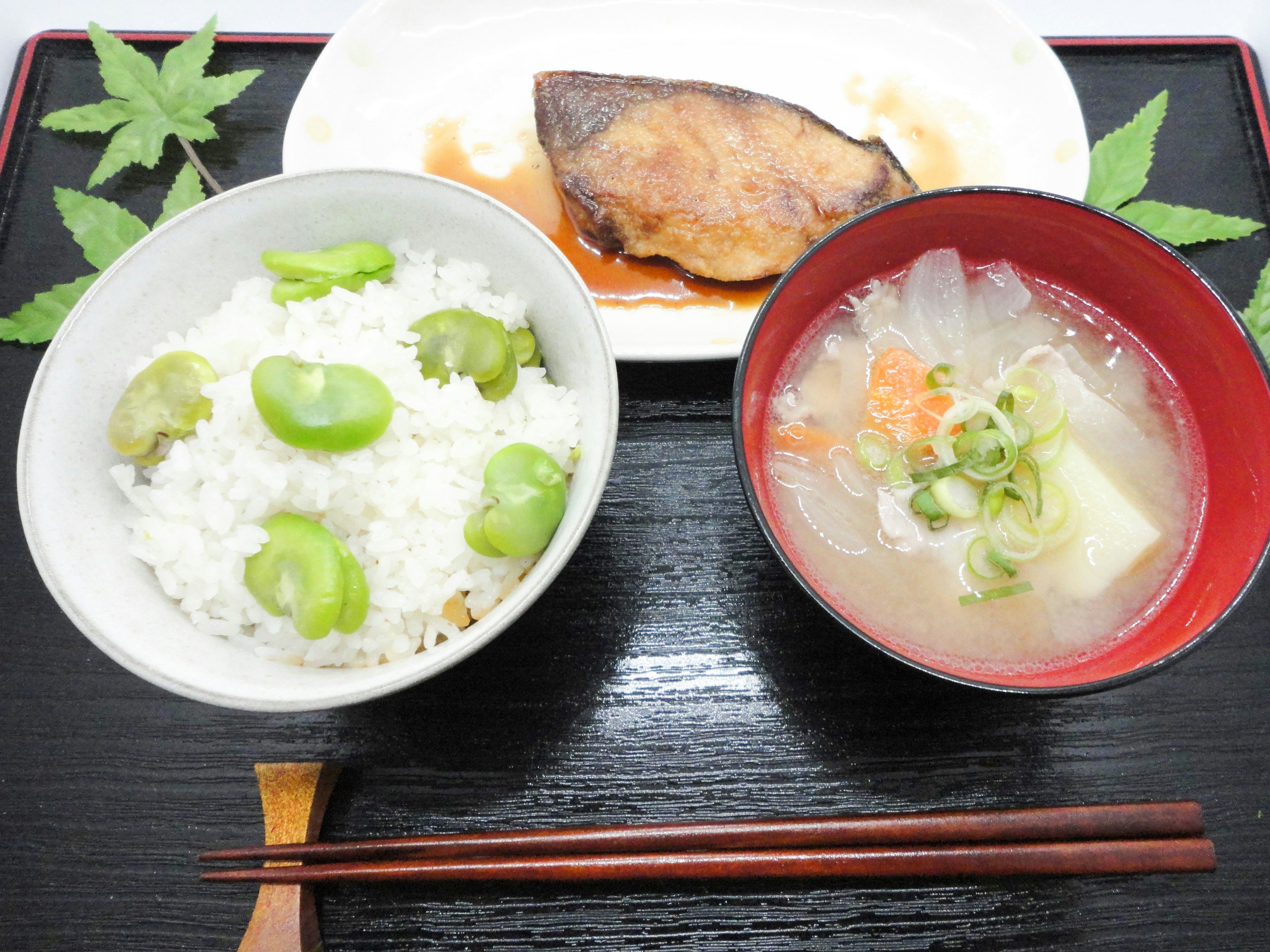 Repas japonais avec du riz aux fèves, de la soupe miso et du poisson grillé