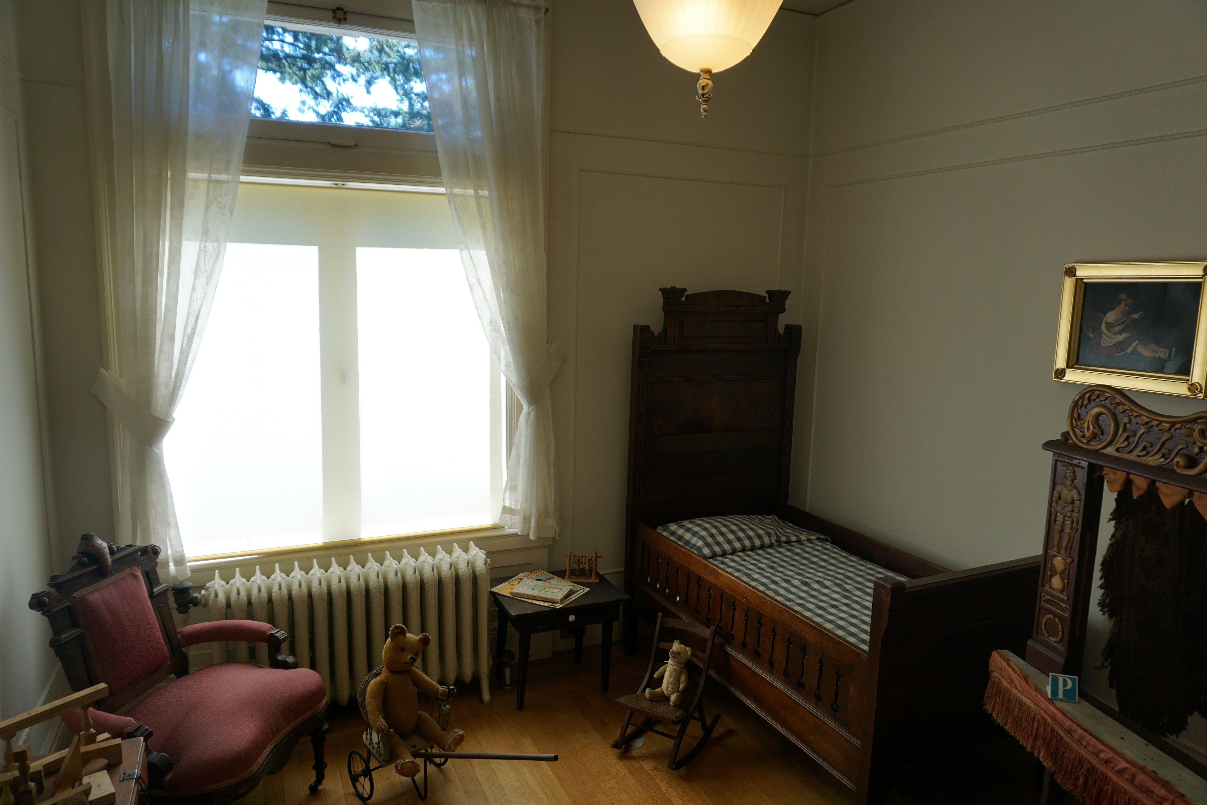 Classic bedroom with bright windows featuring an old bed and decorative chair