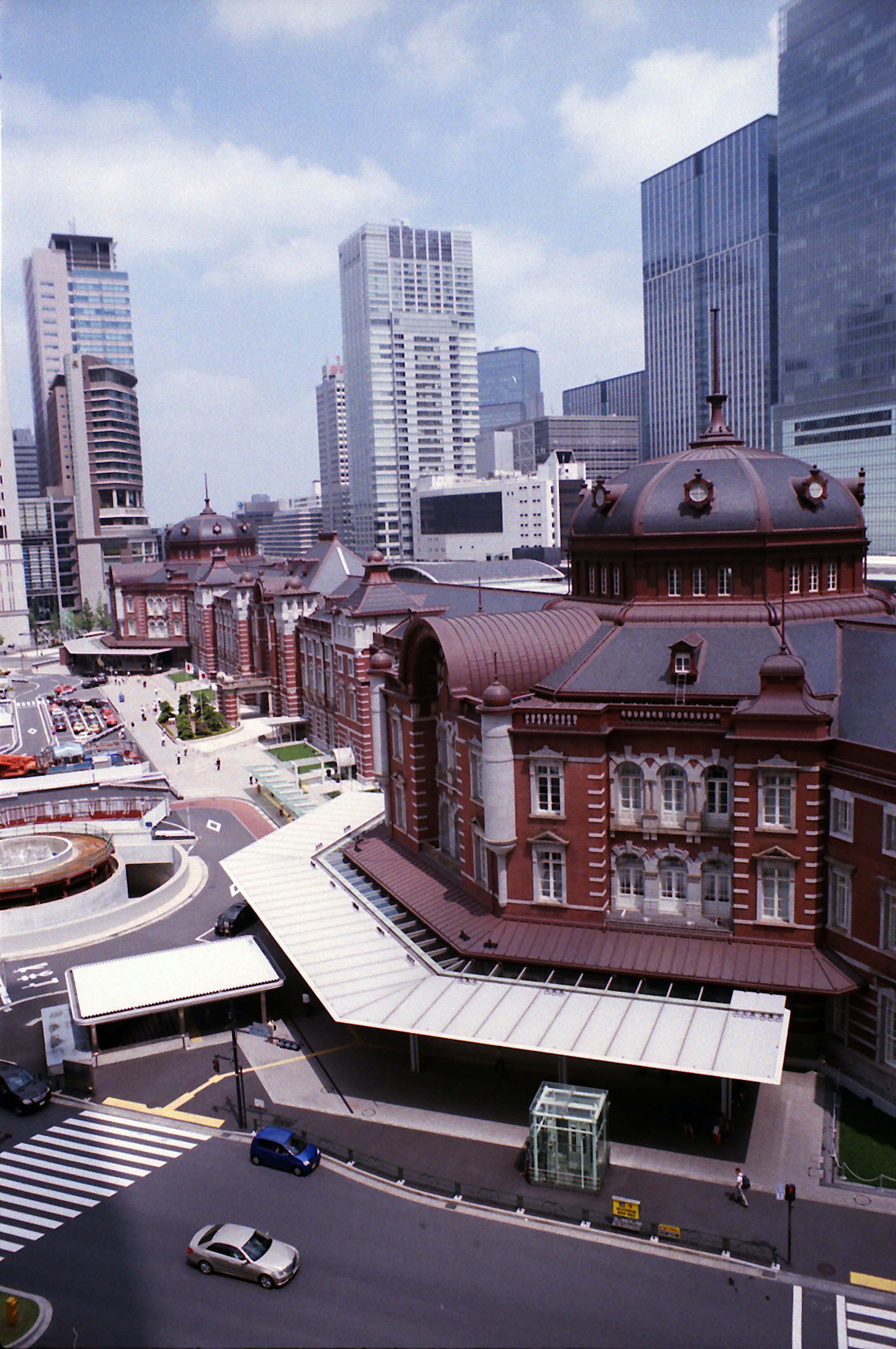 Historic Tokyo Station building with modern skyscrapers in the background