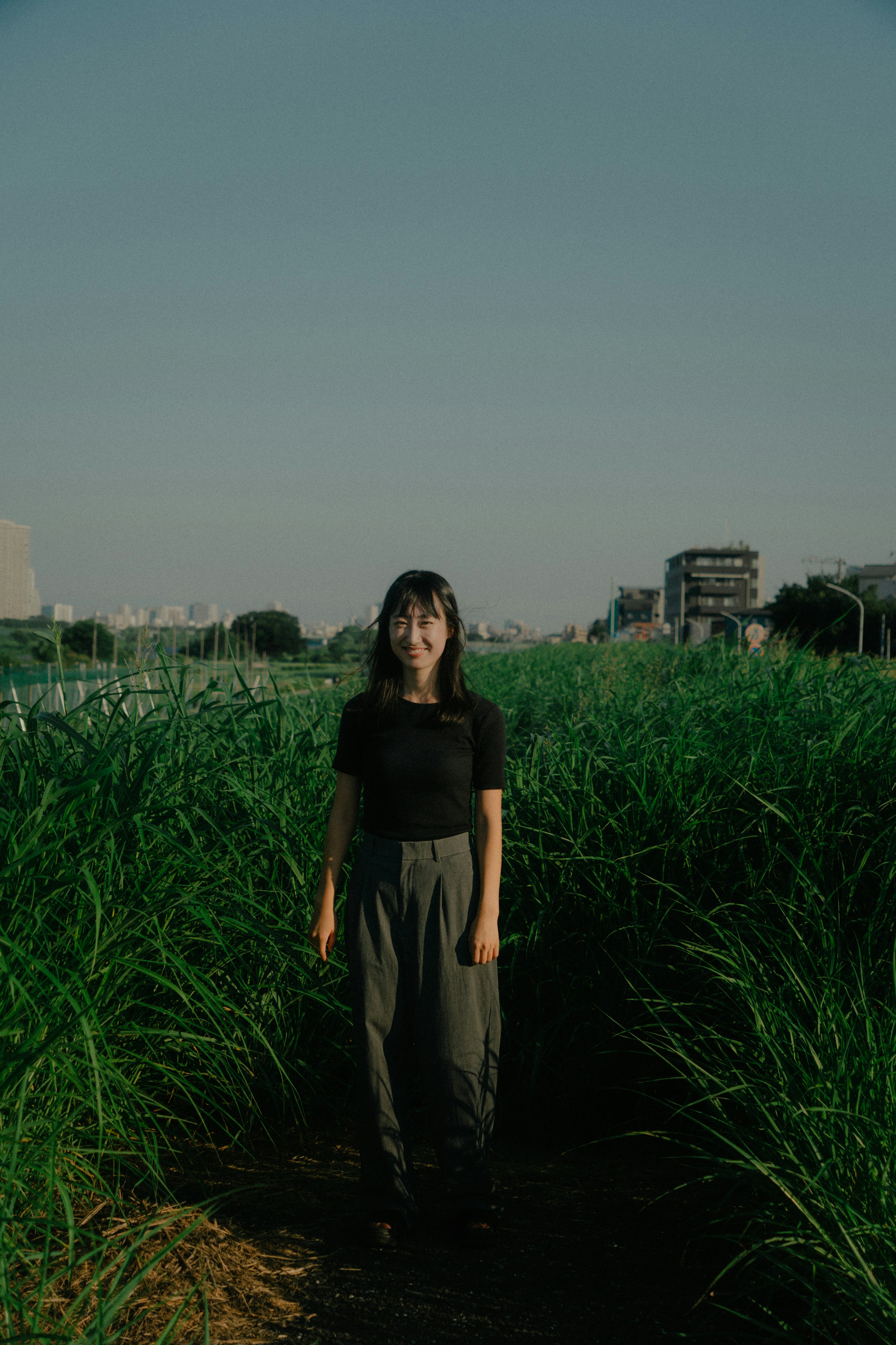 緑の草原の中に立つ女性のポートレート