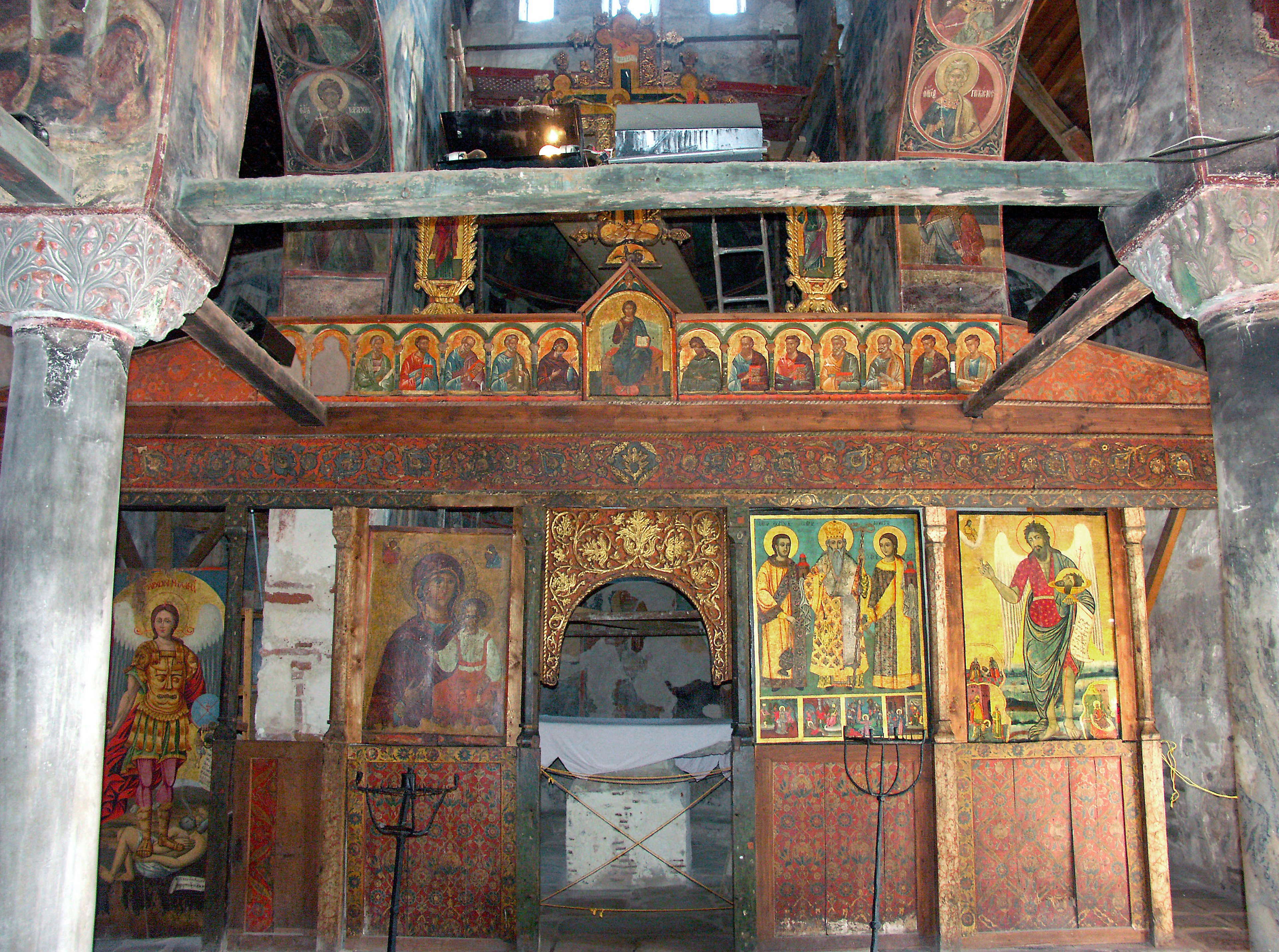 Interior of an old church featuring decorative murals and icons