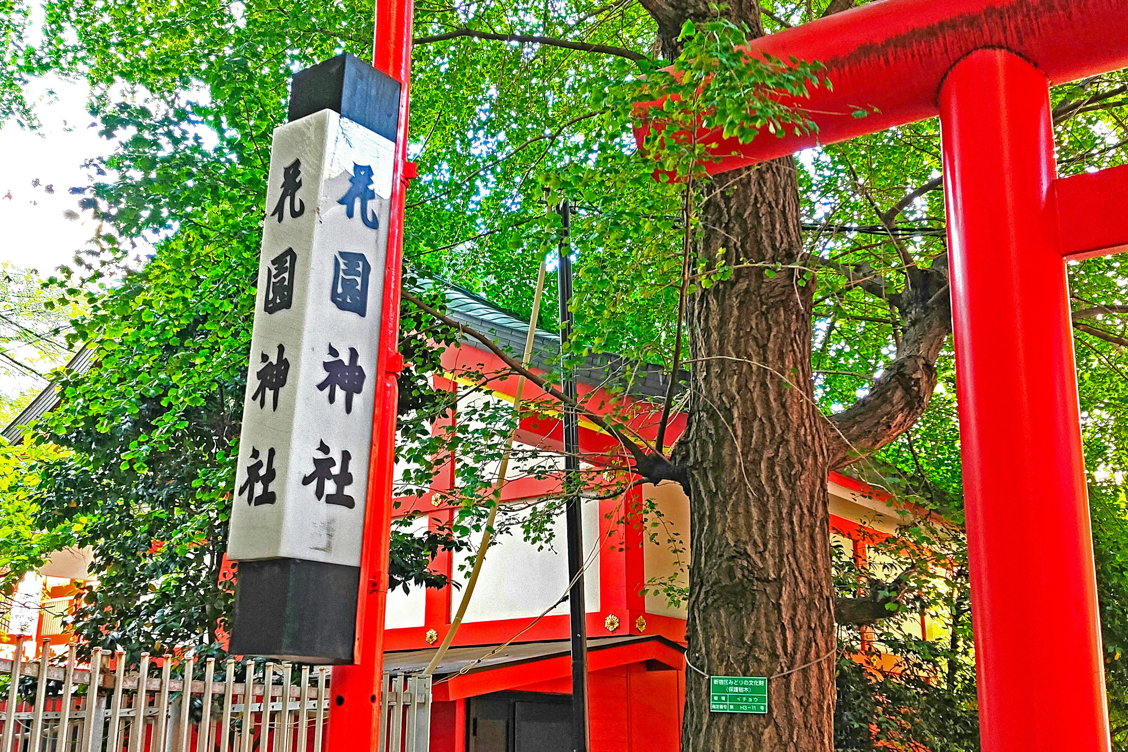 赤い鳥居と神社の看板が見える風景