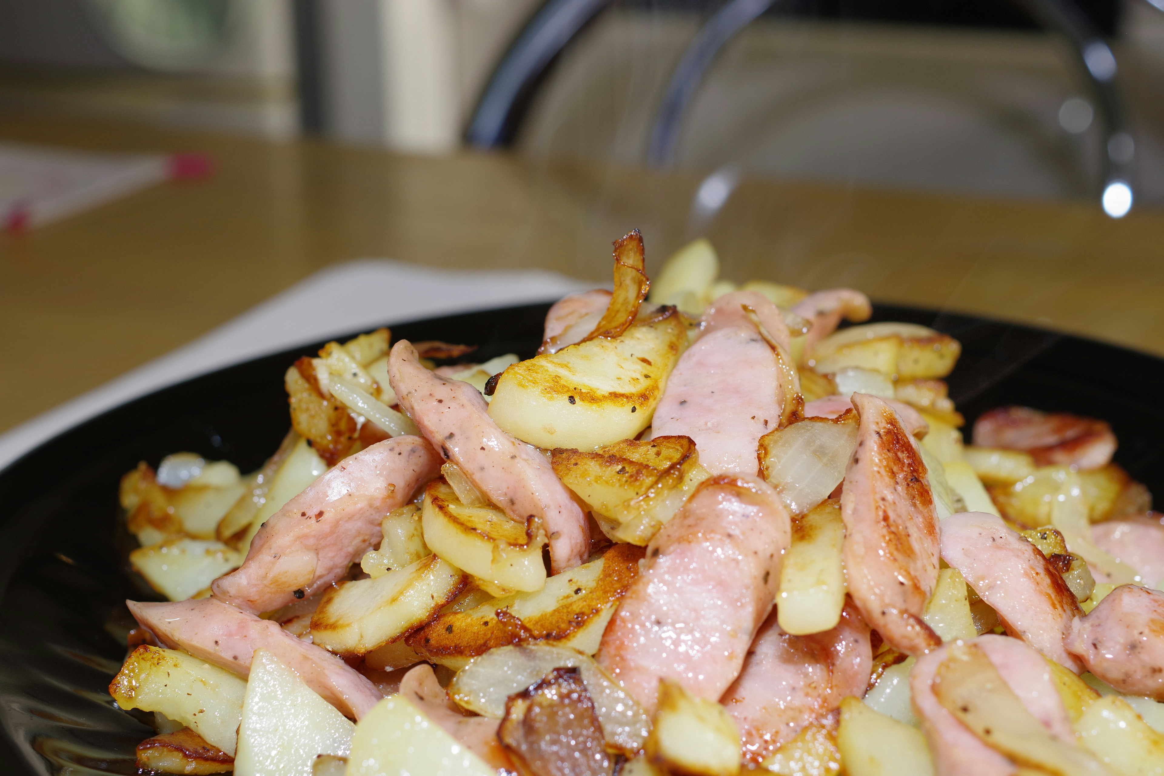 Une assiette de pommes de terre frites croustillantes et de saucisses tranchées