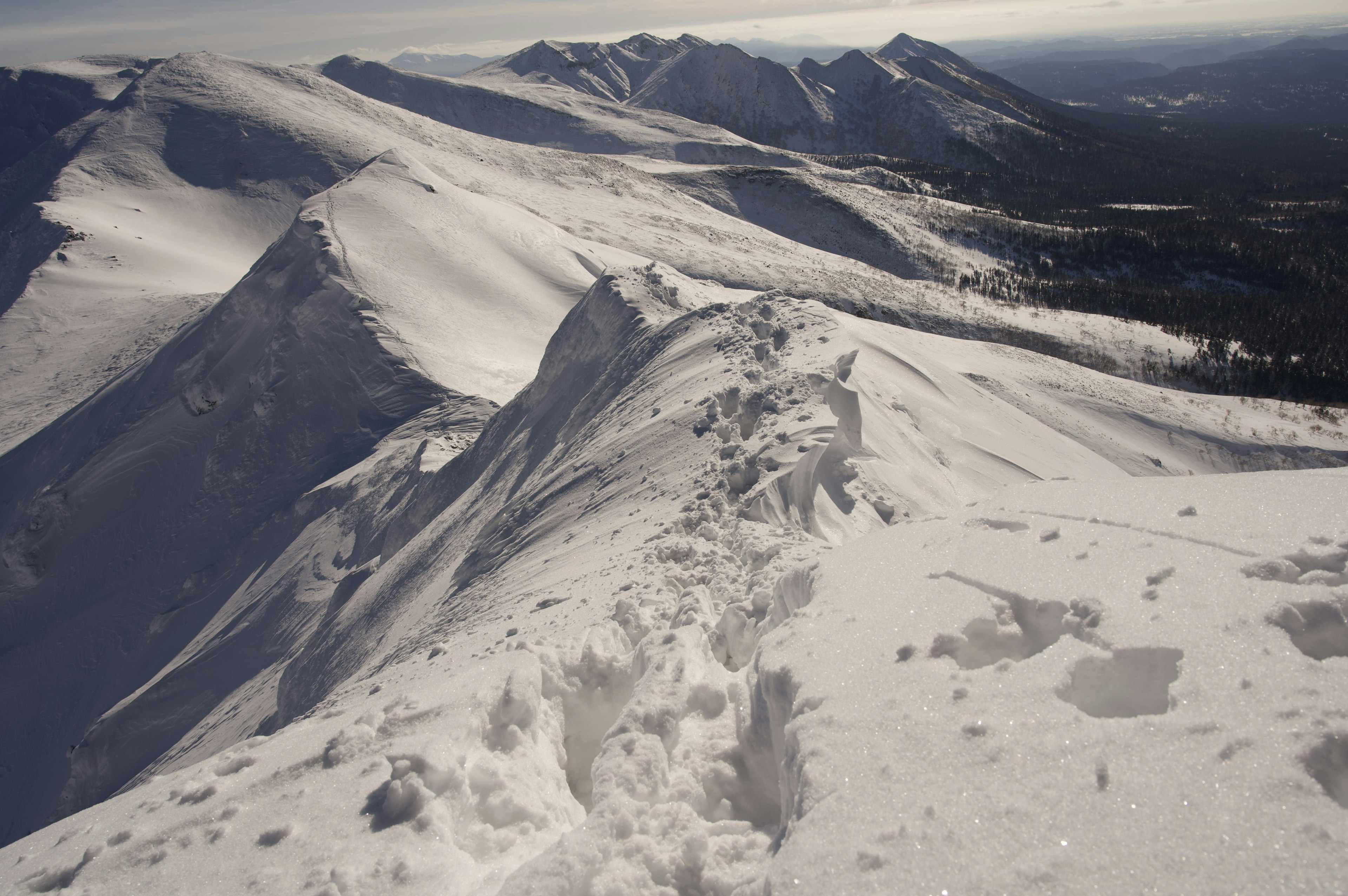 Paysage de sommet de montagne enneigé avec des empreintes visibles