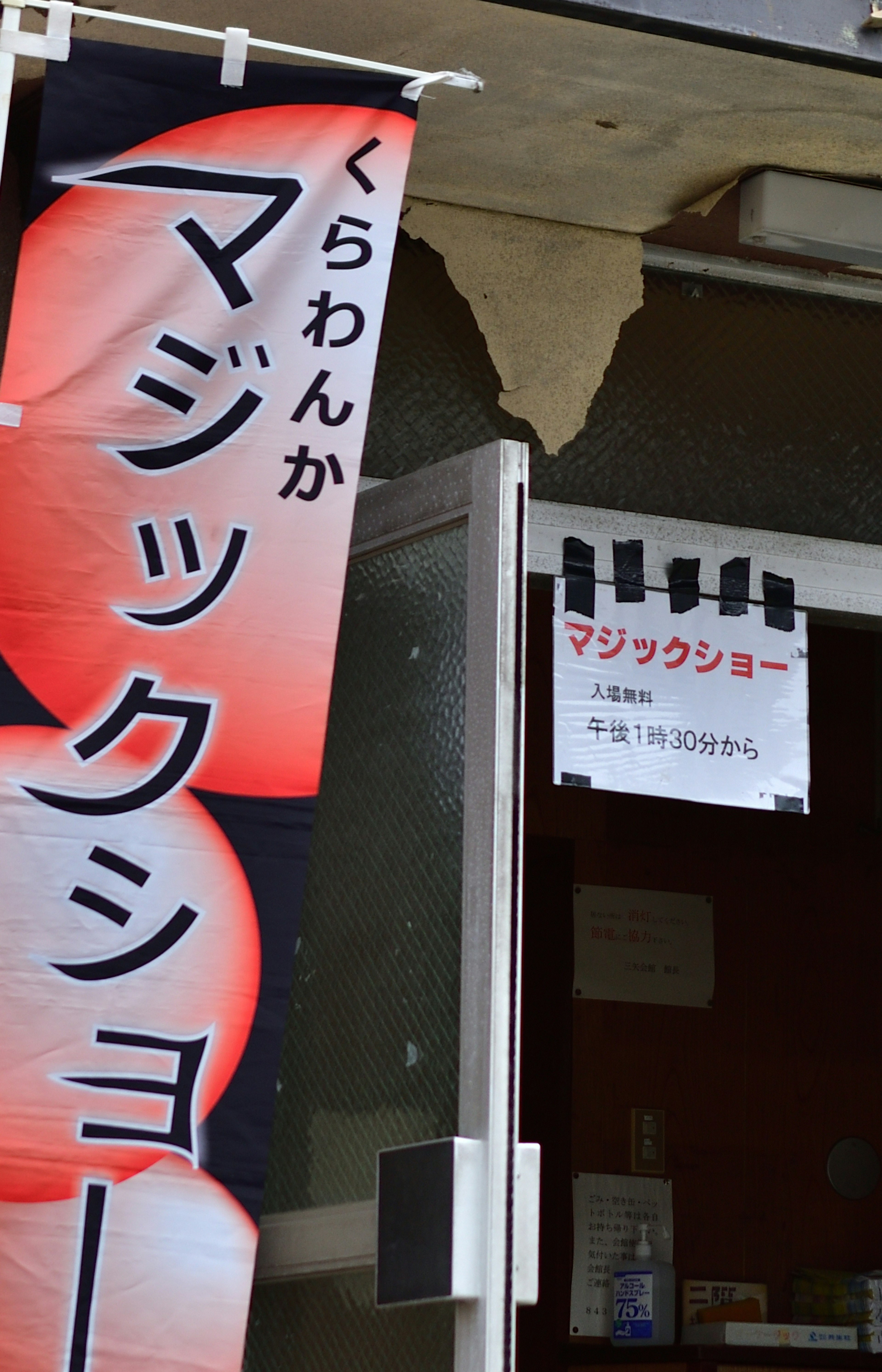 Red banner advertising a magic show with a notice near the door