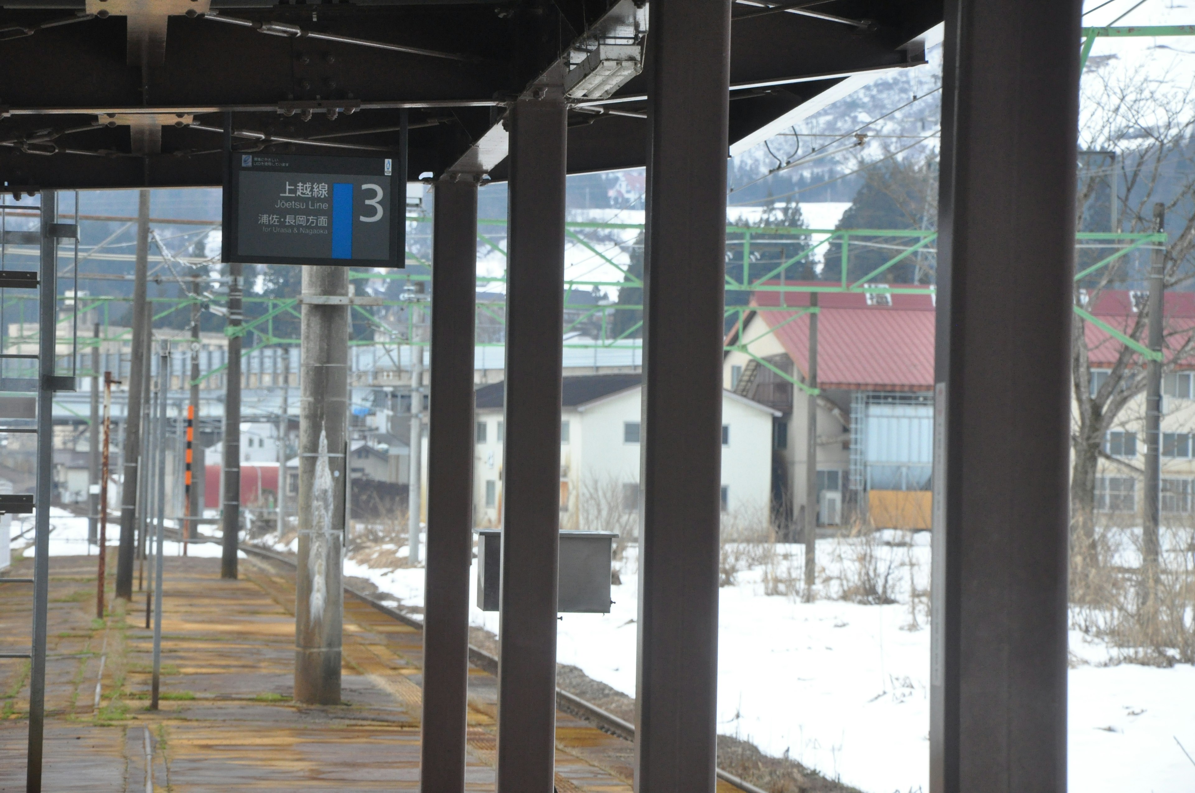 Schneebedeckte Bahnsteig mit Signaltafel