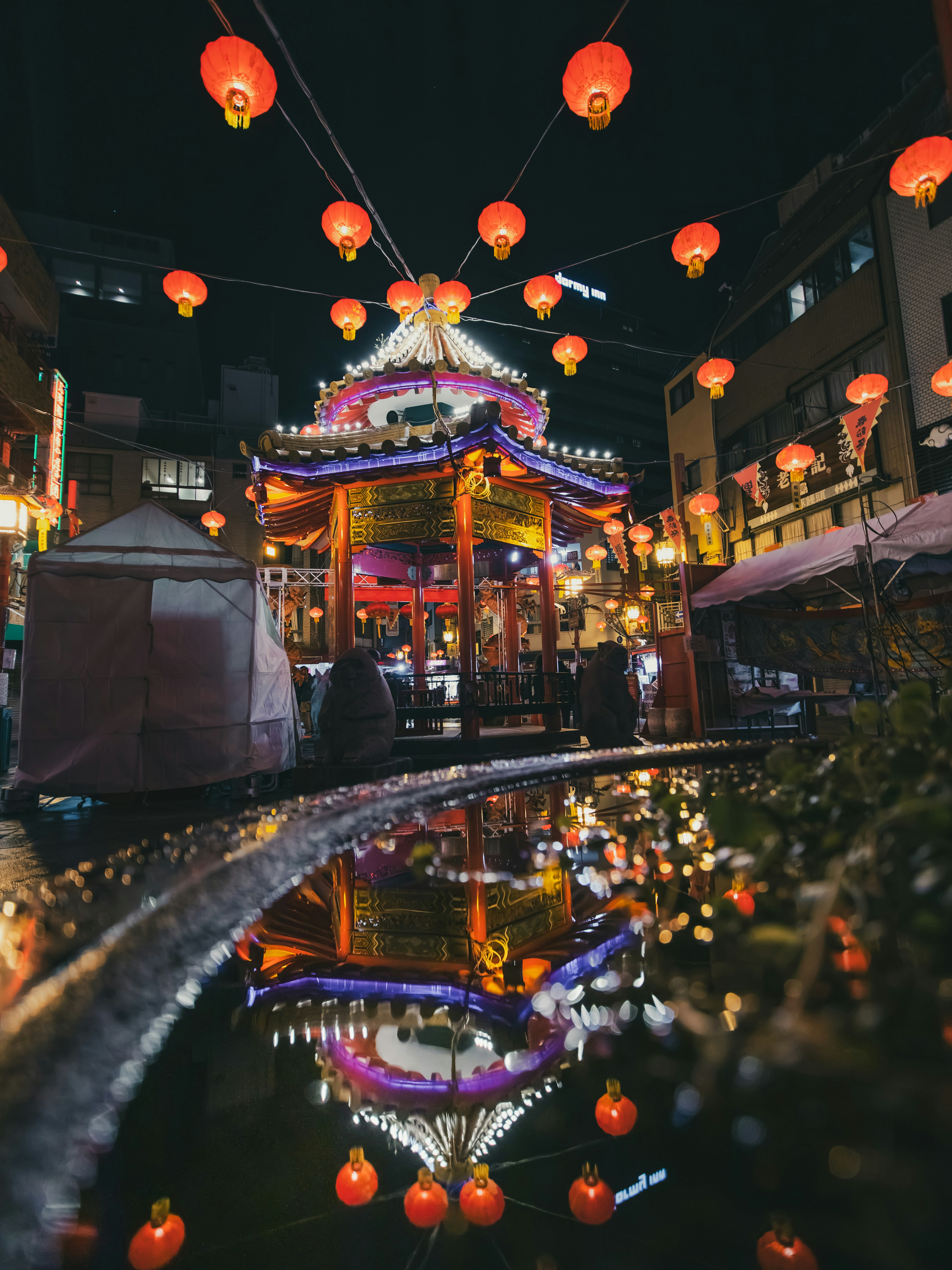 Schönes chinesisches Gebäude, das bei Nacht Laternen reflektiert