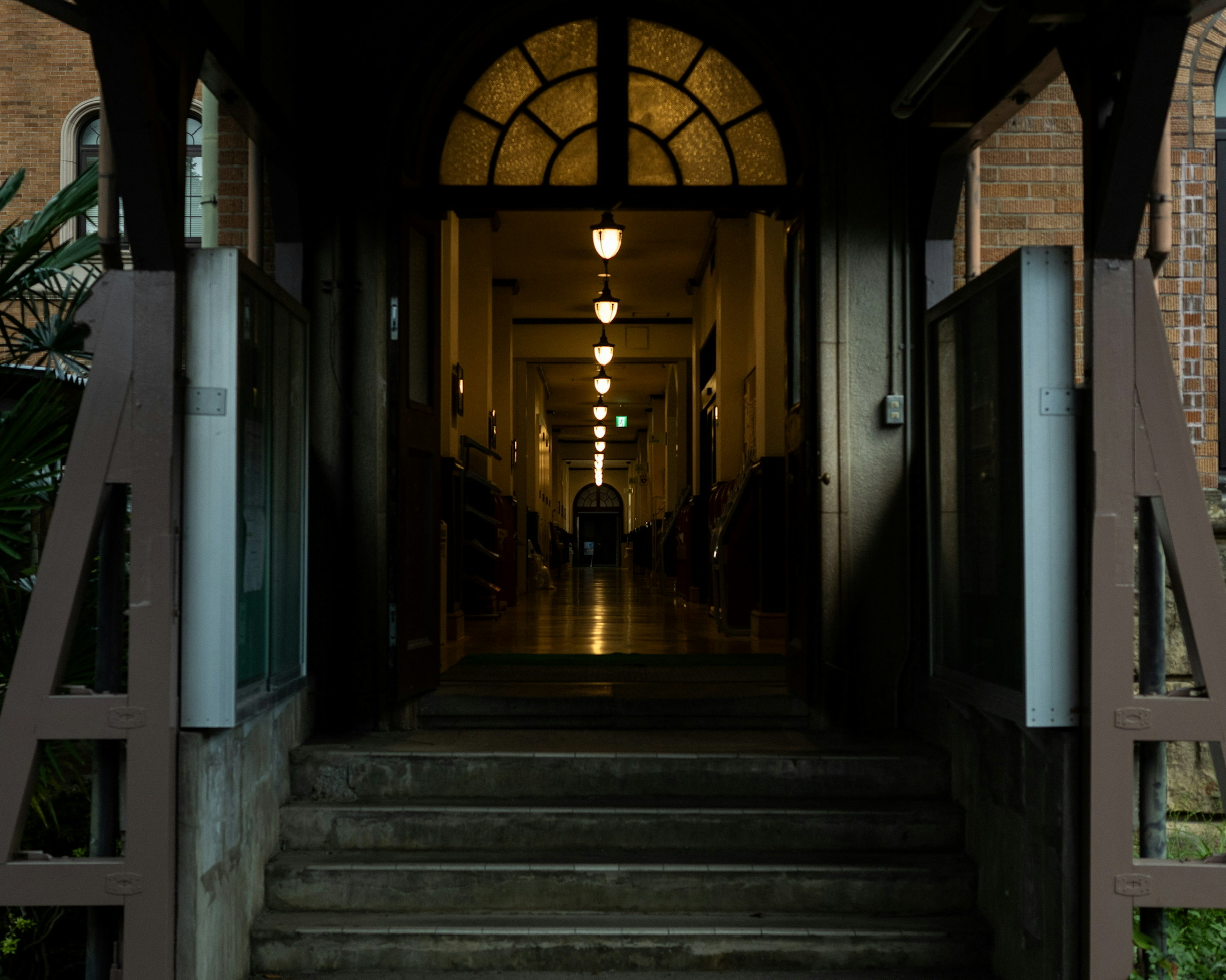 View of a hallway from the entrance of a building with an archway and lined lights