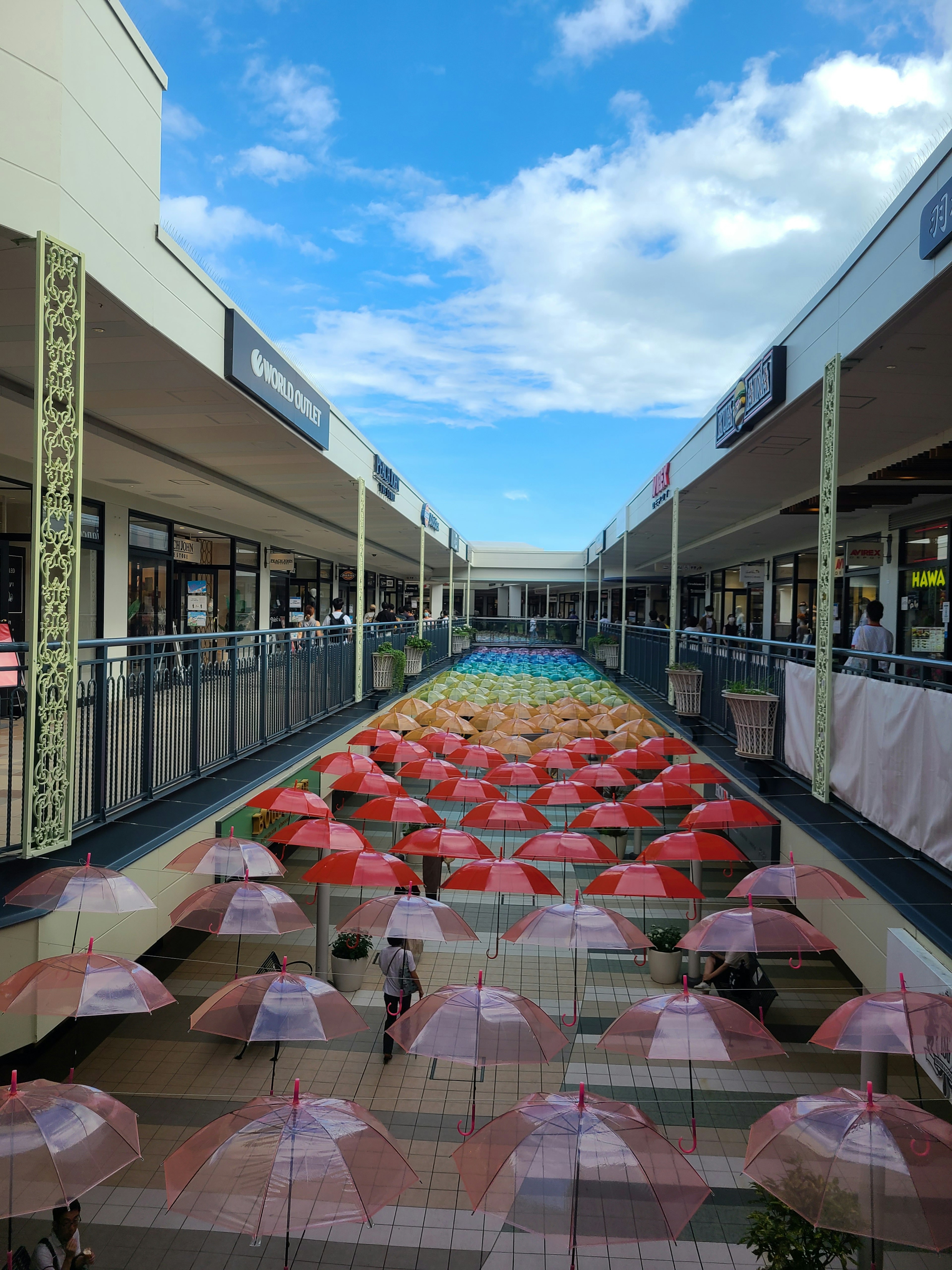 Allée de centre commercial bordée de parapluies colorés