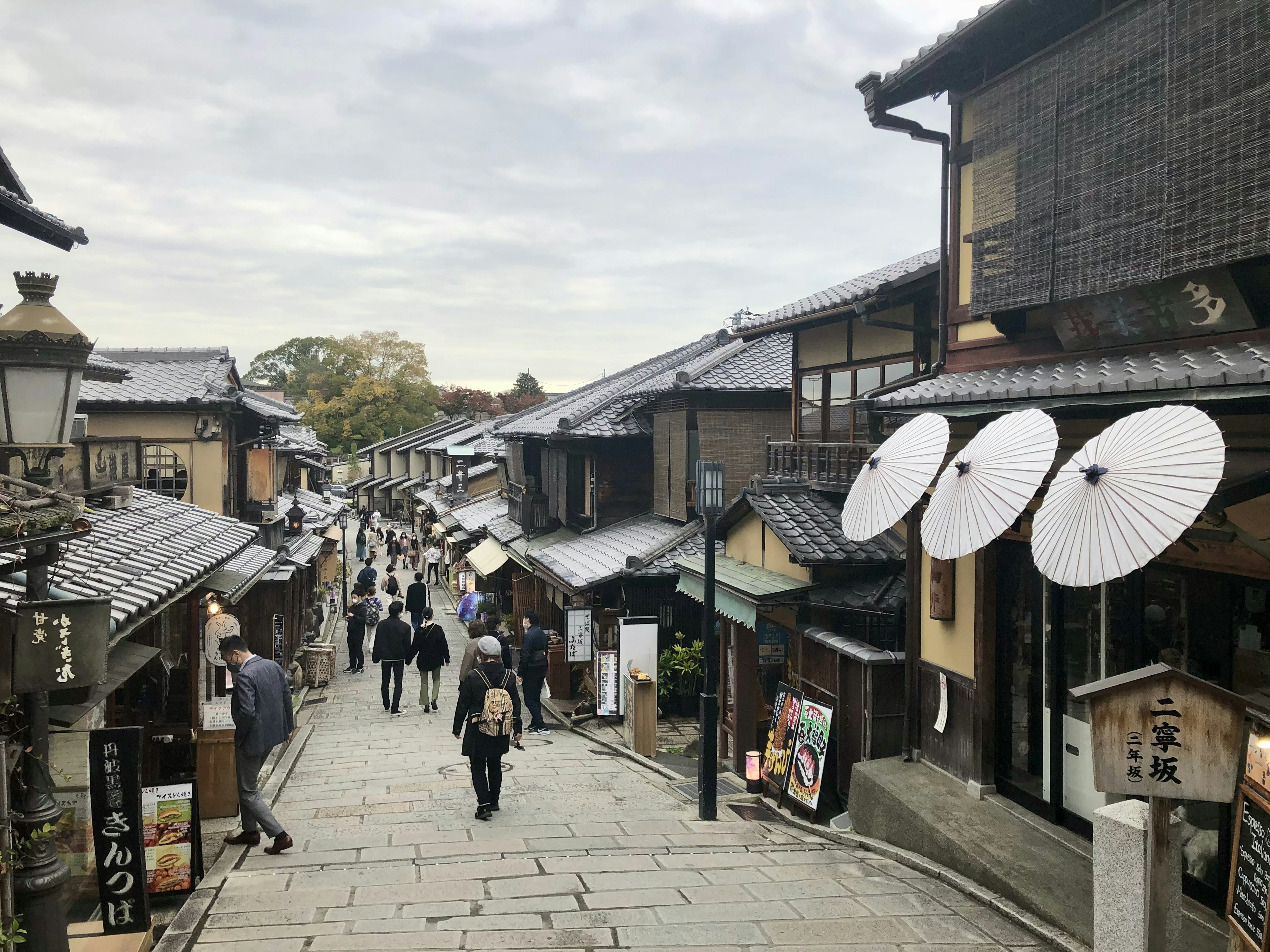 传统街道场景，行人和雨伞在历史背景中