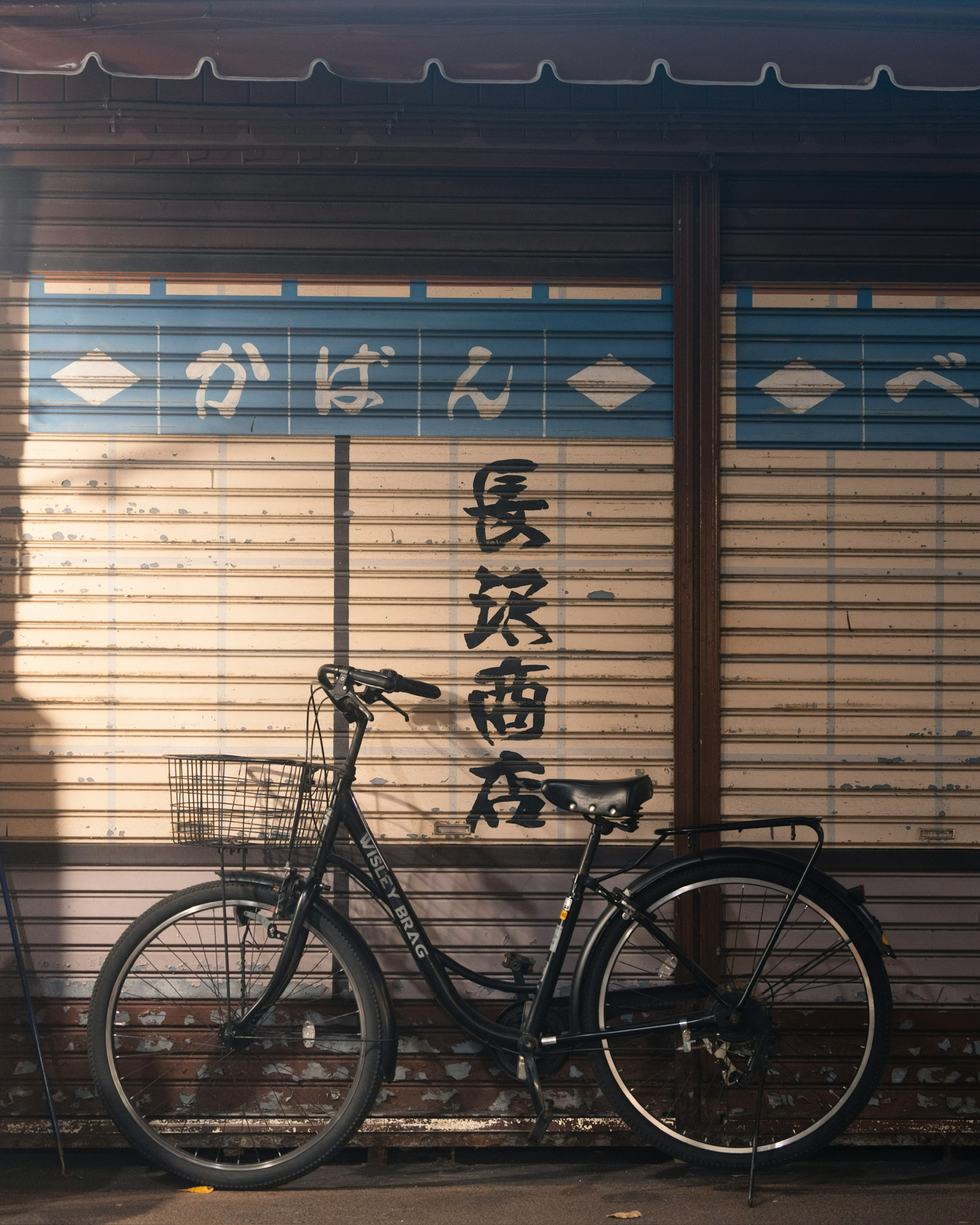 黒い自転車が古い商店の前に置かれている