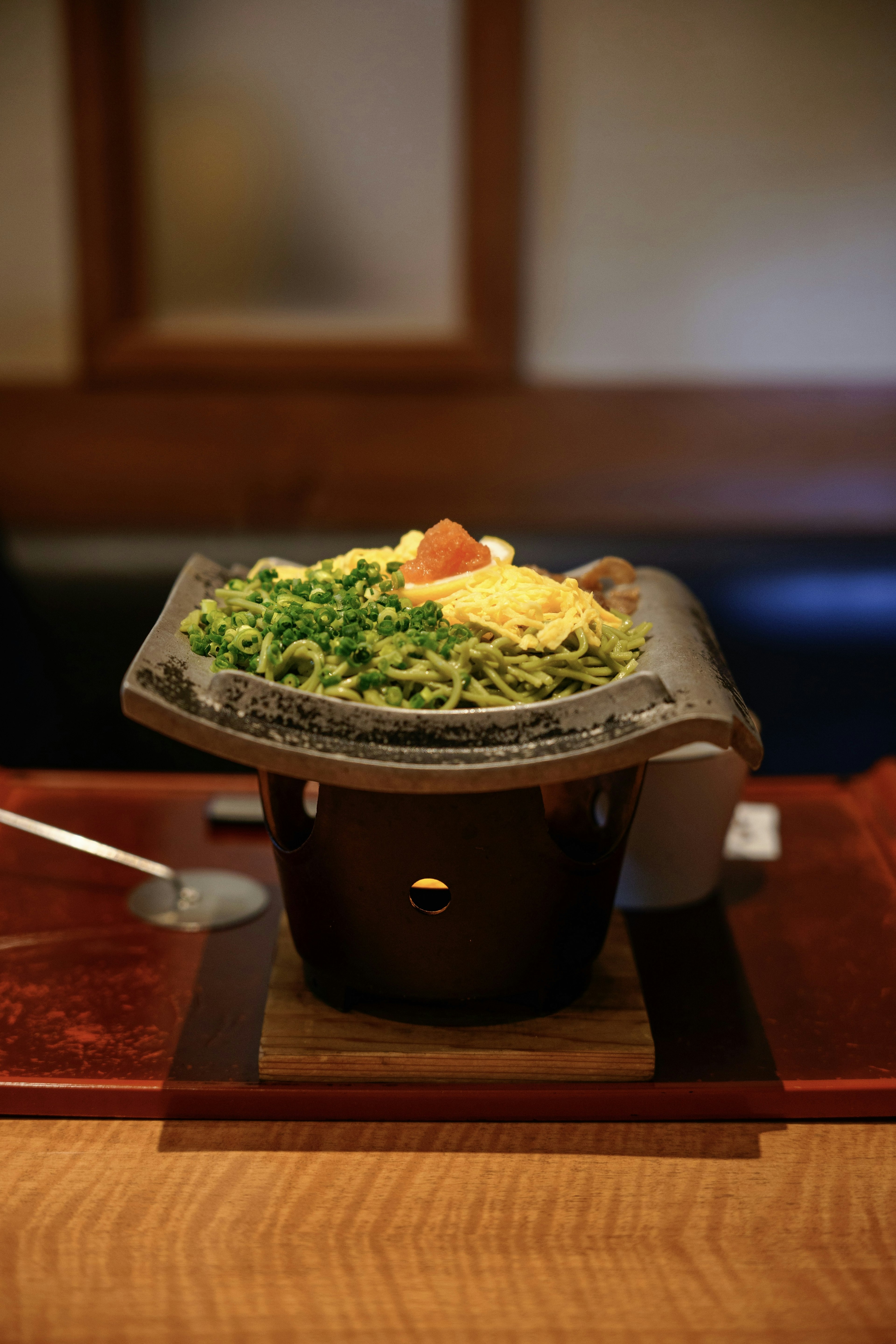 Un plato cocinado en piedra servido sobre una mesa de madera